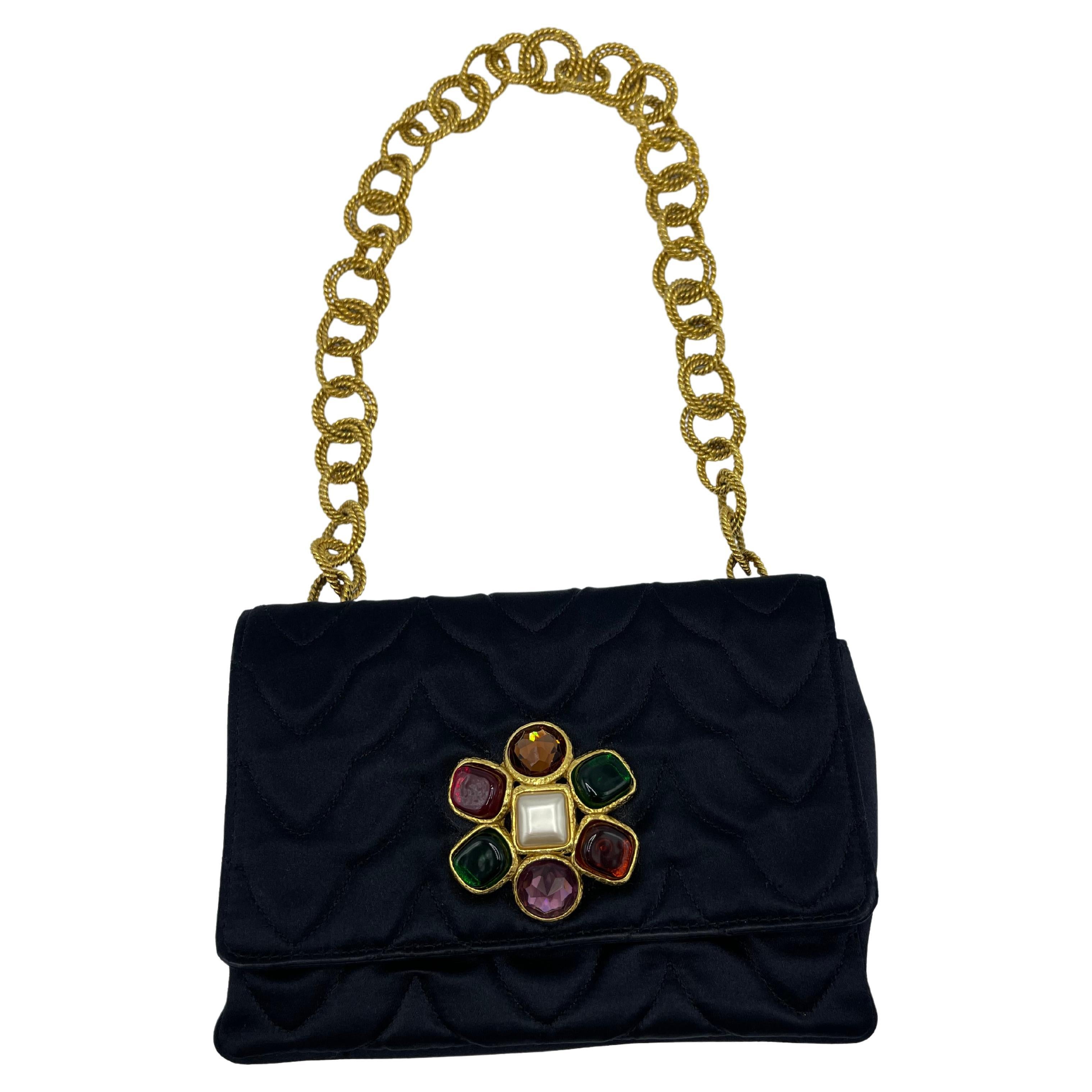 Rare Chanel Gripoix collectable bag. In perfect condition. The purse is made of satin, the chain strap is constructed of doubled circular and oval links, each link is in a rope design in gold. 
In the front of the bag we can see a Gripoix