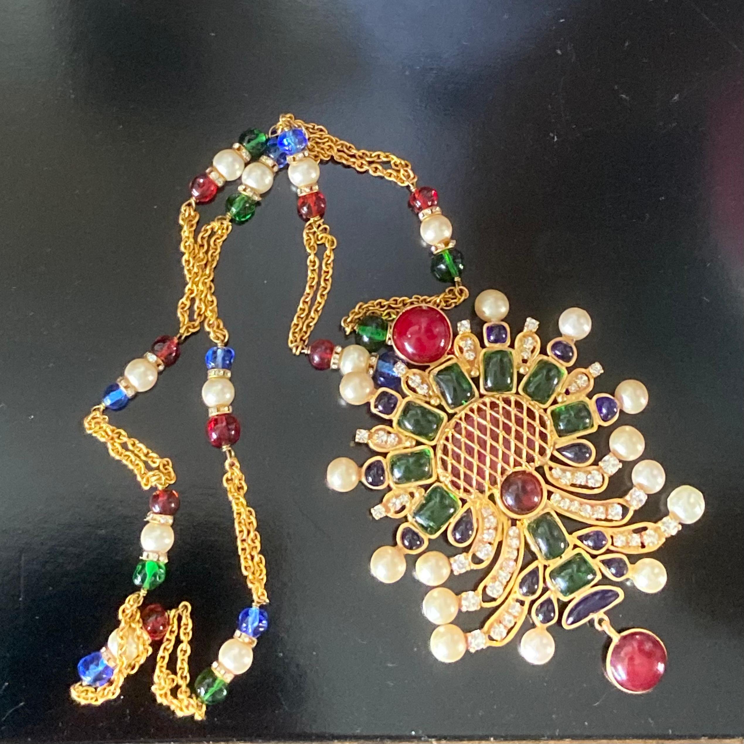 Il s'agit d'un collier à pendentifs en verre Gripoix de Robert Goossens, de style byzantin, très recherché et reconnu par Chanel, datant du début des années 1980.
 
Décorée de panneaux de verre Gripoix rouge, vert et bleu avec des accents de strass