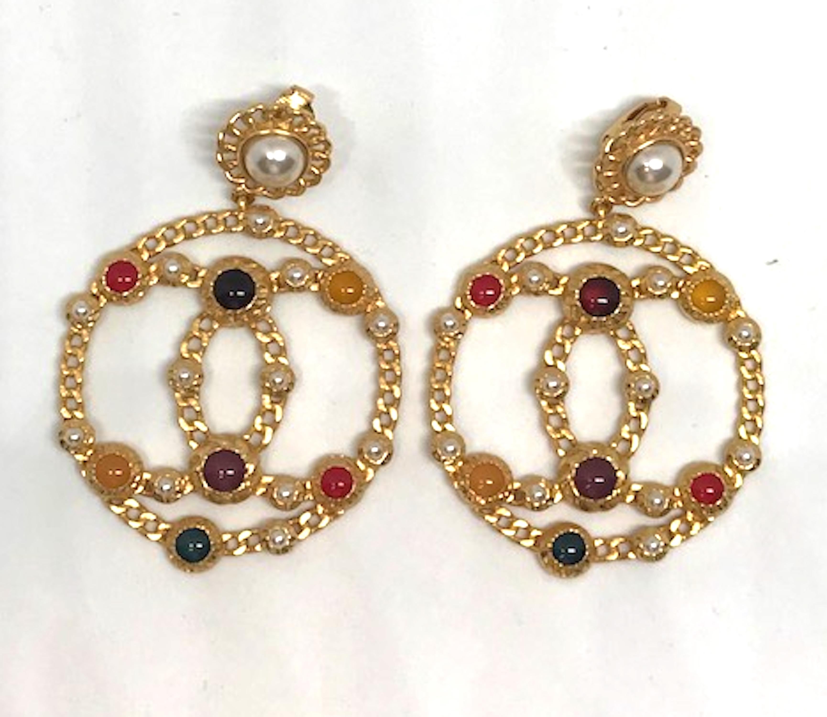 A lovely pair of Chanel gold tone, Gripoix glass cabochon and faux seed pearl earrings. The earrings feature Chanel's double CC logo in a circle suspended from a clip back pearl center button. All done in Chanel's famous gold chain design. The back