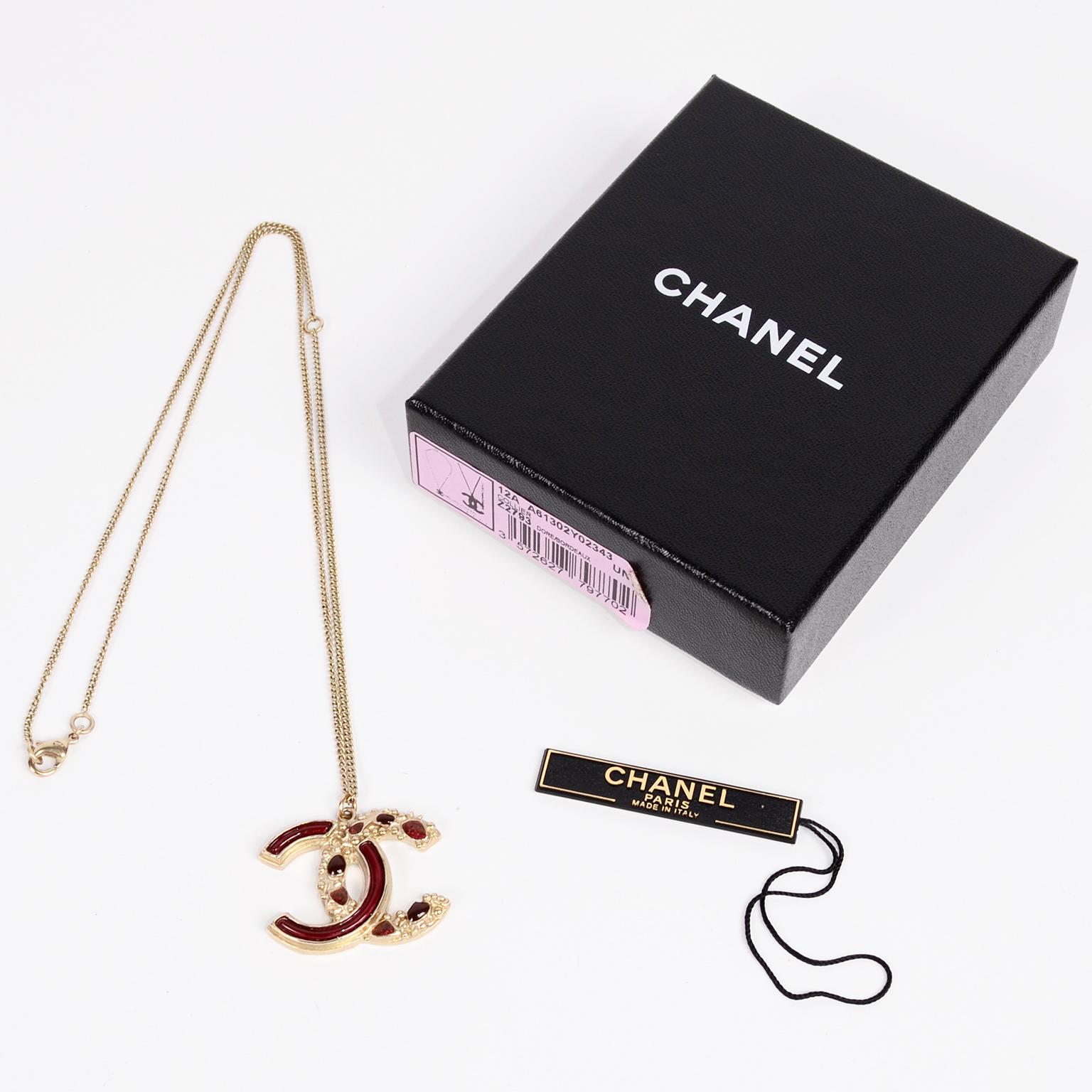 This is a gorgeous Fall 2012 Chanel CC Pendant Necklace with its original box and tag.  The back of the CC logo is a sparkle maroon and the front has the same maroon with the second C having individual gripoix (poured glass) stones filled into the