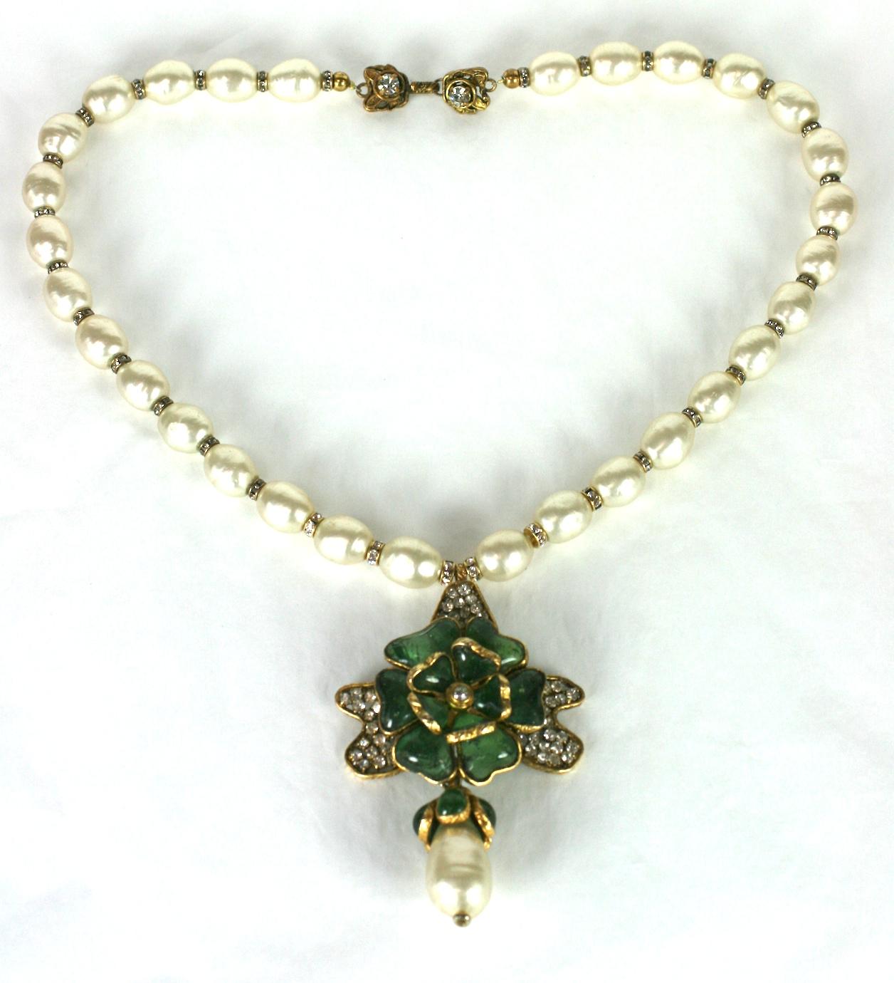 Elegant and striking Chanel Gripoix Flower Pendant Necklace of handmade oval faux pearls, which are strung with tiny pave rondels. The hand made poured glass flower by Gripoix is emerald glass within a handmade setting of pave petals. 
A large faux