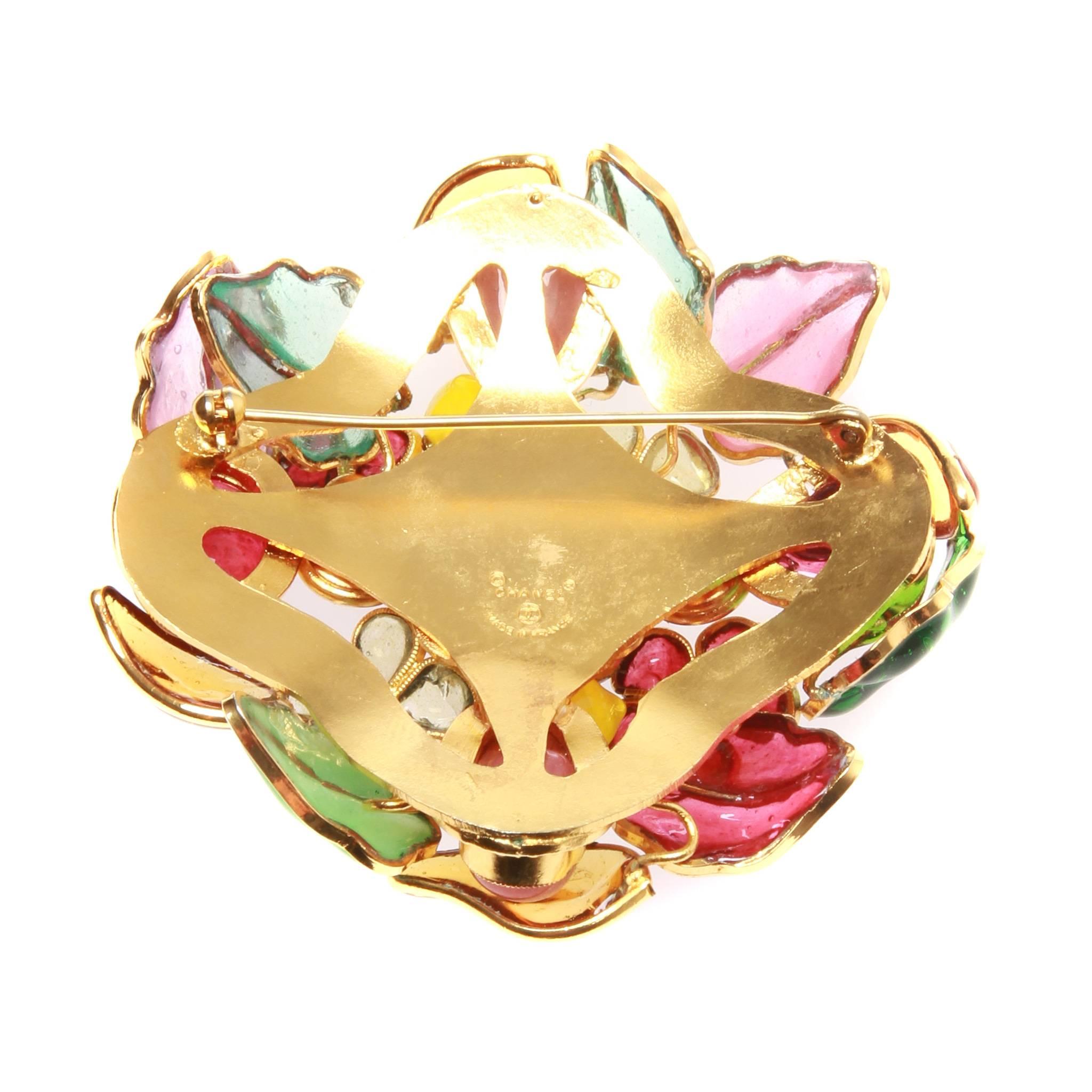 Vintage Chanel brooch formed of multi-coloured Gripoix glass in a floral design set in bright gold-tone mental. 

Roll needle at back. Chanel stamp dates it to the period of 1971-80.

With box