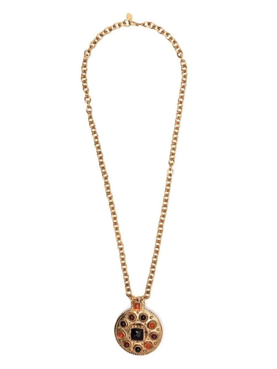 Crafted from a gold-toned metal, this vintage Chanel Gripoix from the 1970's necklaces displays a large shield pendant with black and orange cabochons hanging from a chunky chain that secures using a hook clasp. Wear it against a bare décolletage