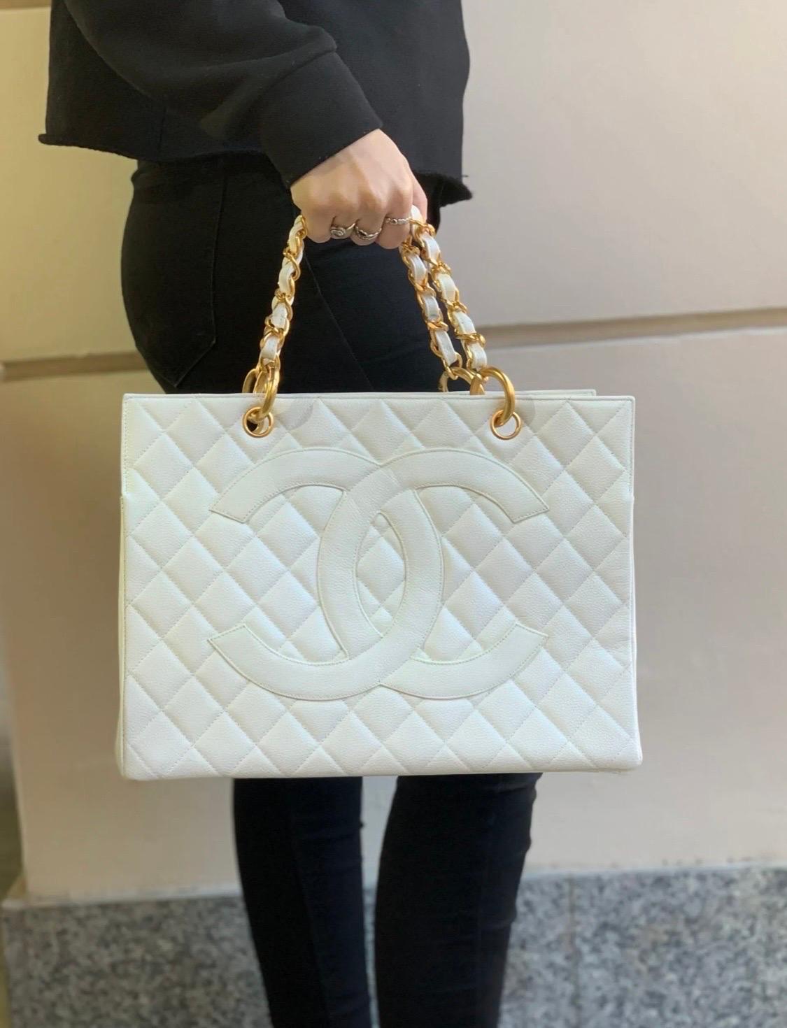 Borsa firmata Chanel, modello GST, realizzata in pelle bianca trapuntata con hardware oro. Munita di due manici superiori centrali in pelle bianca e catena intrecciati. Predispone di un’ampia apertura centrale, internamente rivestita in pelle