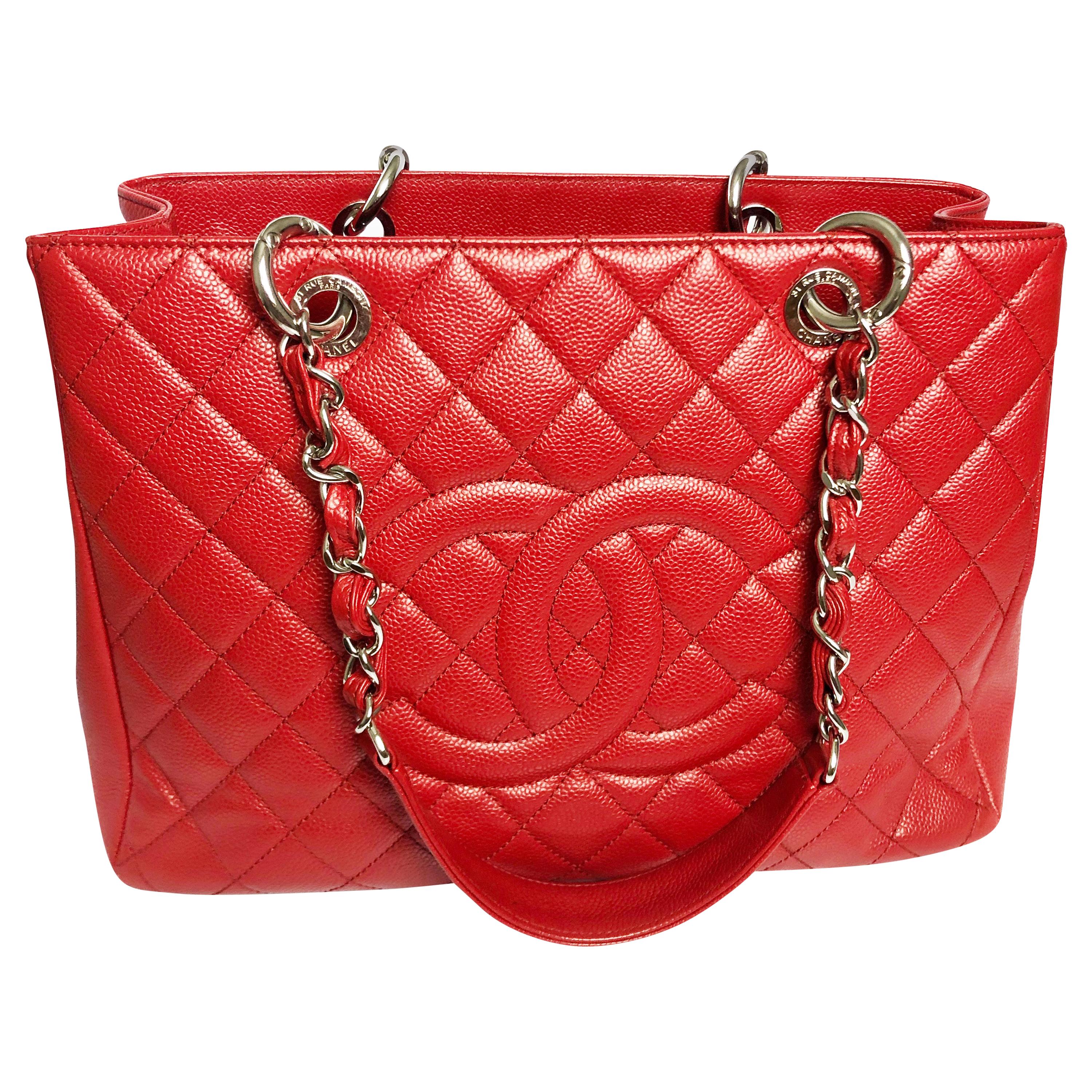 Authentic, preowned Chanel GST Grand Shopping Tote in red caviar leather with silver hardware from the 2013 collection.  Made from red caviar diamond-quilted or matelasse leather, it features a slip pocket in back, silver chain link and red leather
