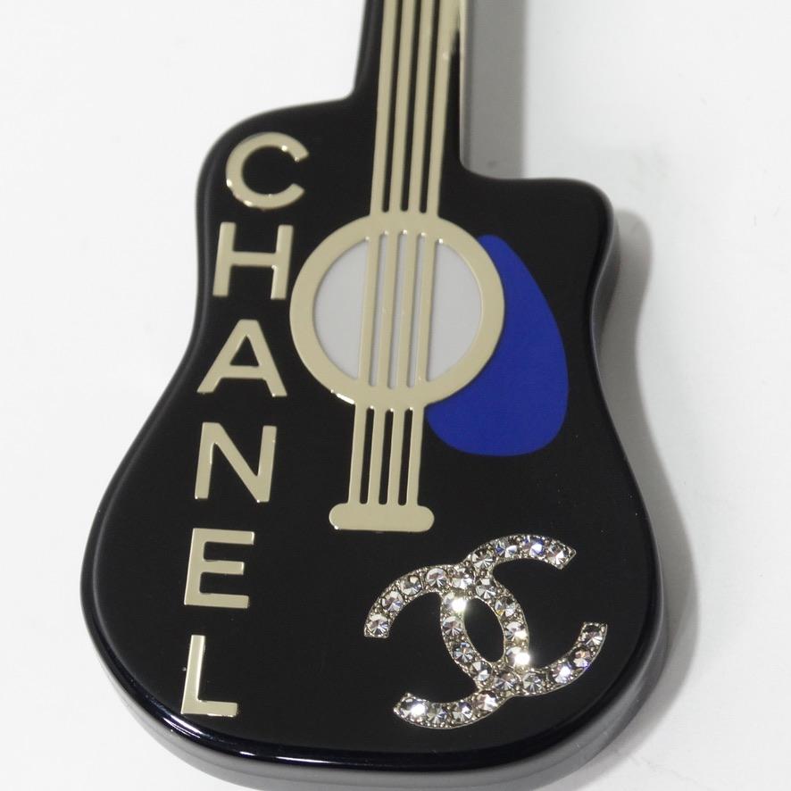 Iconic Chanel guitar brooch circa 2020. Featuring a gold Chanel logo, a cobalt accent, and pearl and diamond decals, this brooch is as unique as it is versatile. Pin this to your denim Louis Vuitton jacket to add a fun flare to your look! Or add