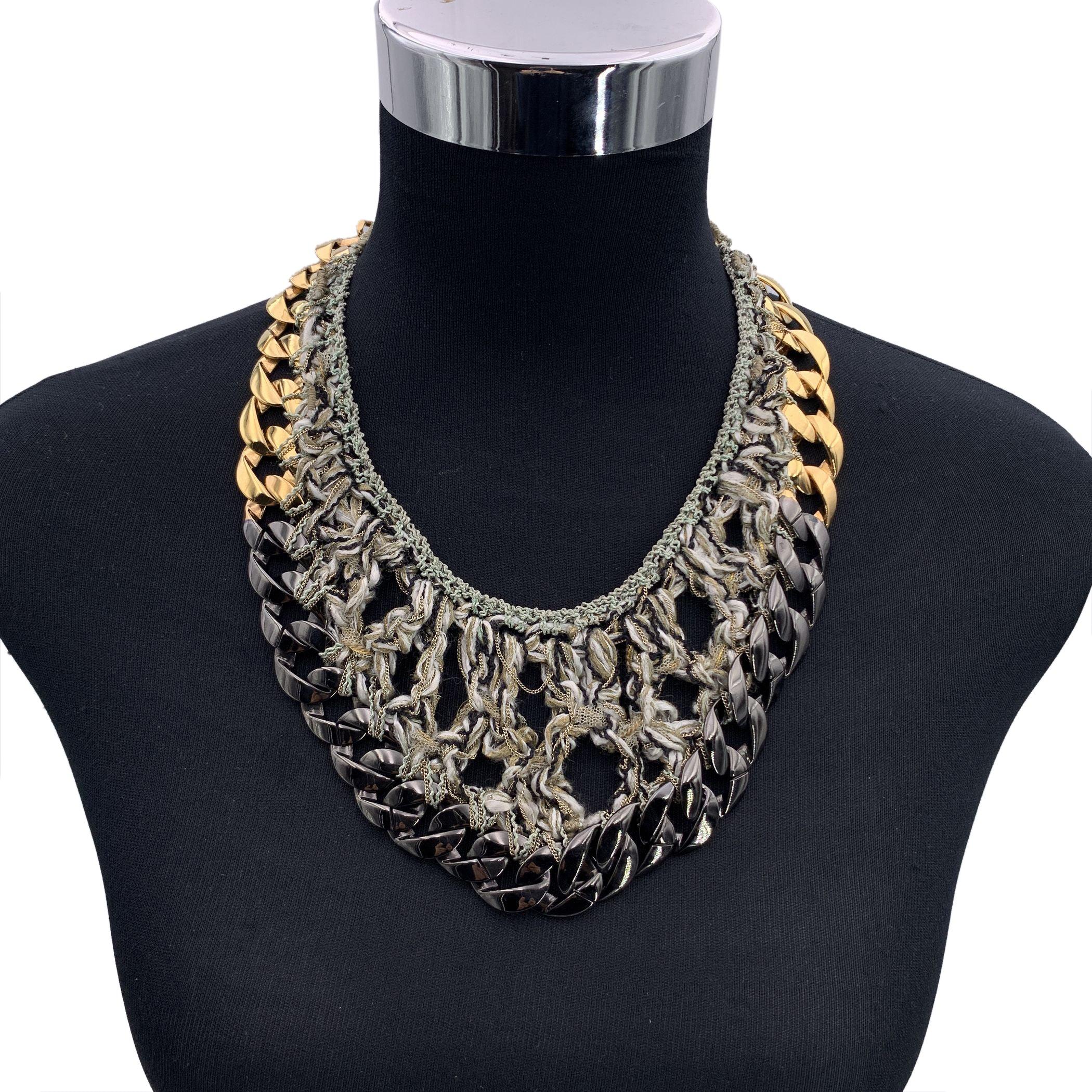 Beautiful Chanel bib necklace from the Spring 2011 Collection. Gunmetal and gold metal chain with grey tweed woven throughout the chain links. Lobster closure with CC accent. Signed 'CHANEL - B11 CC P- Made in Italy' oval hallmark on the closure.