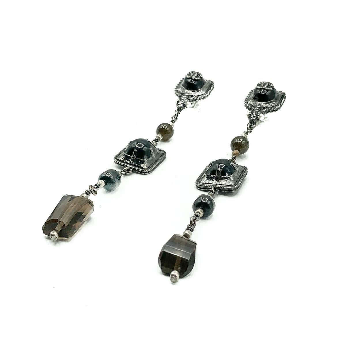 Mesmerizingly long Chanel Gunmetal Drop Earrings. Crafted in grey tone metal and set with resins, gold speckled glass beads, faux seed pearls and faceted glass droplets resembling natural smoky quartz. Finished with the iconic logo on the ear. In