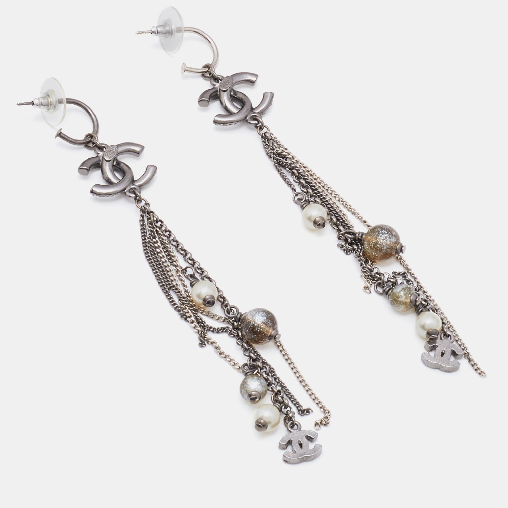 Designed with a gunmetal tone, these long dangle earrings from Chanel will complement an evening look with ease. They feature faux pearls, crystals, beads, and the iconic CC logo motifs. Highlight your outfits with this elegant pair.

