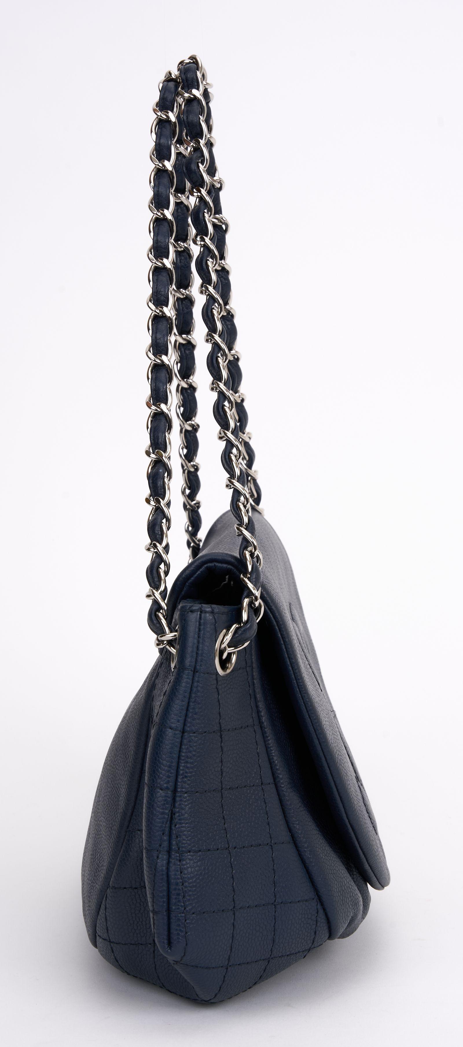 This Chanel Half Moon Flap in blue can be worn as a shoulder bag or held in the hand. The handbag features a polished silver chain link leather threaded shoulder strap and a facing flap with a quilted stitched Chanel CC logo. The flap opens to a