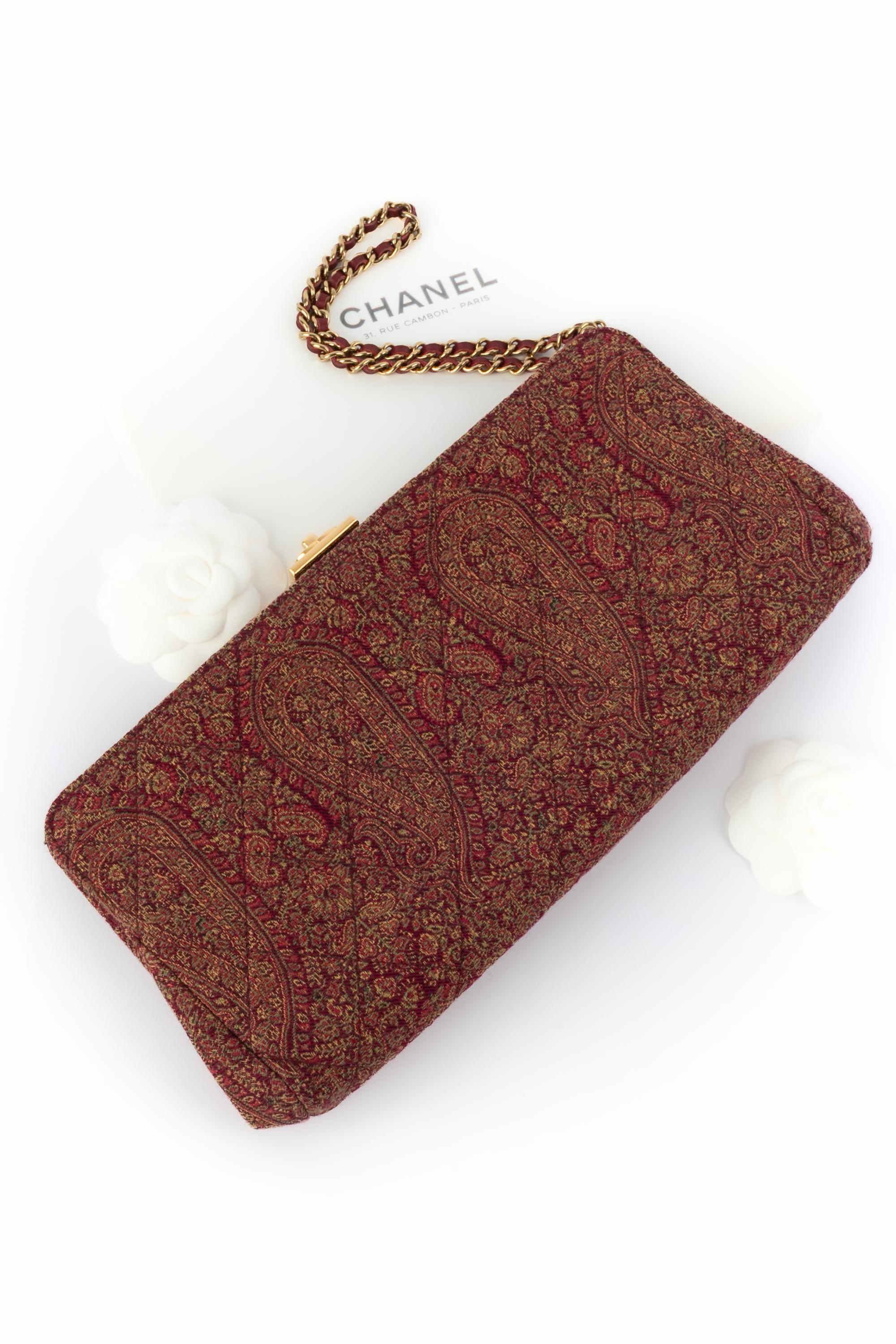 CHANEL - (Made in France) Handtasche aus Stoff mit Paisleymuster in Rot-, Grün- und Gelbtönen. Innen aus burgunderfarbenem Leder. Goldfarbener Metallgriff, verflochten mit Leder und goldenen Metallelementen.

Bedingung:
Sehr guter