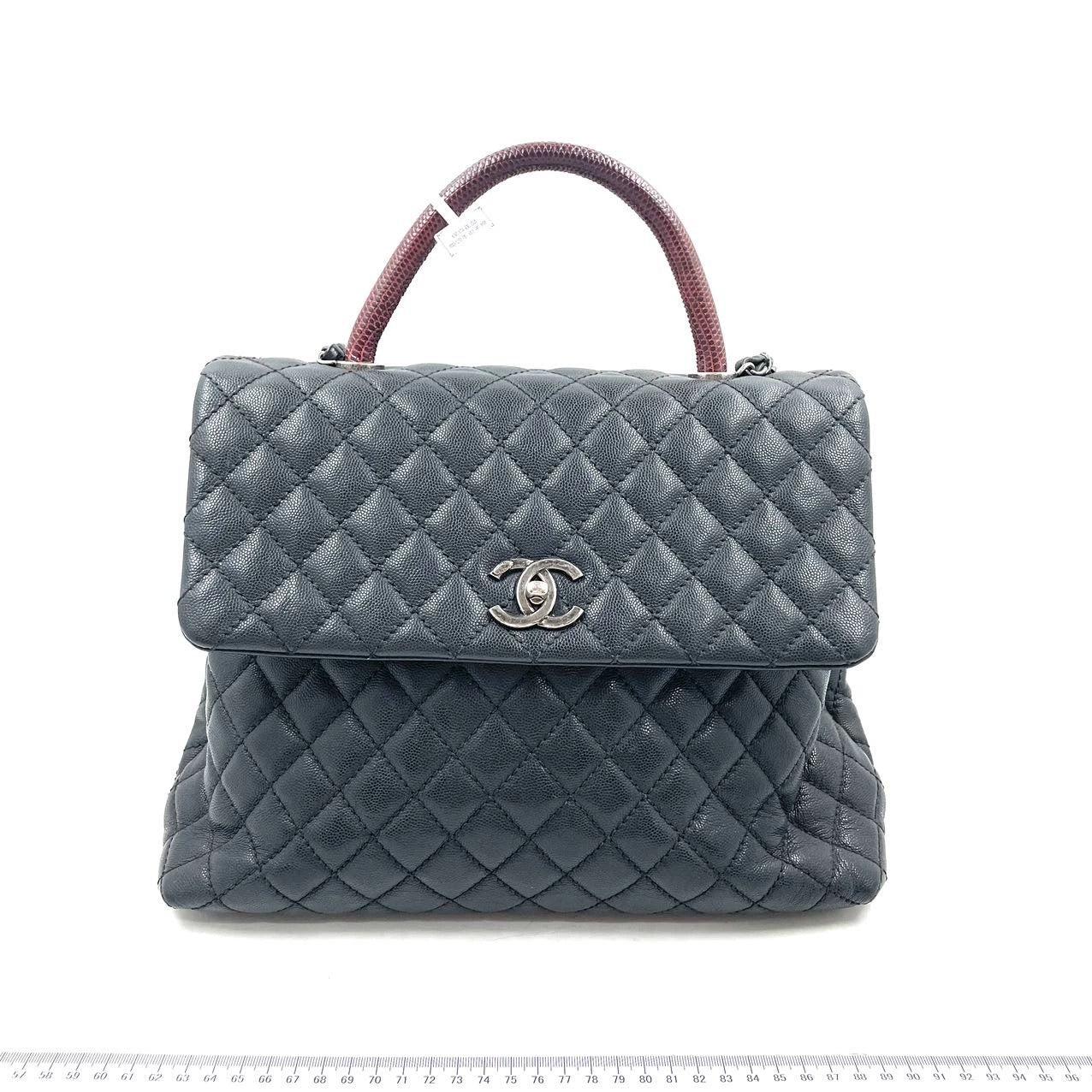 Chanel Coco Handle Maxi Black Caviar Leather Burgundy Lizard Handle Silver Hardware 32cm
 Il s'agit de photos professionnelles du sac.
 ÉTAT : EXCELLENT
 Des plis sur le fond du sac. Il a perdu un peu de sa structure. Taches sur la poignée. Rayures