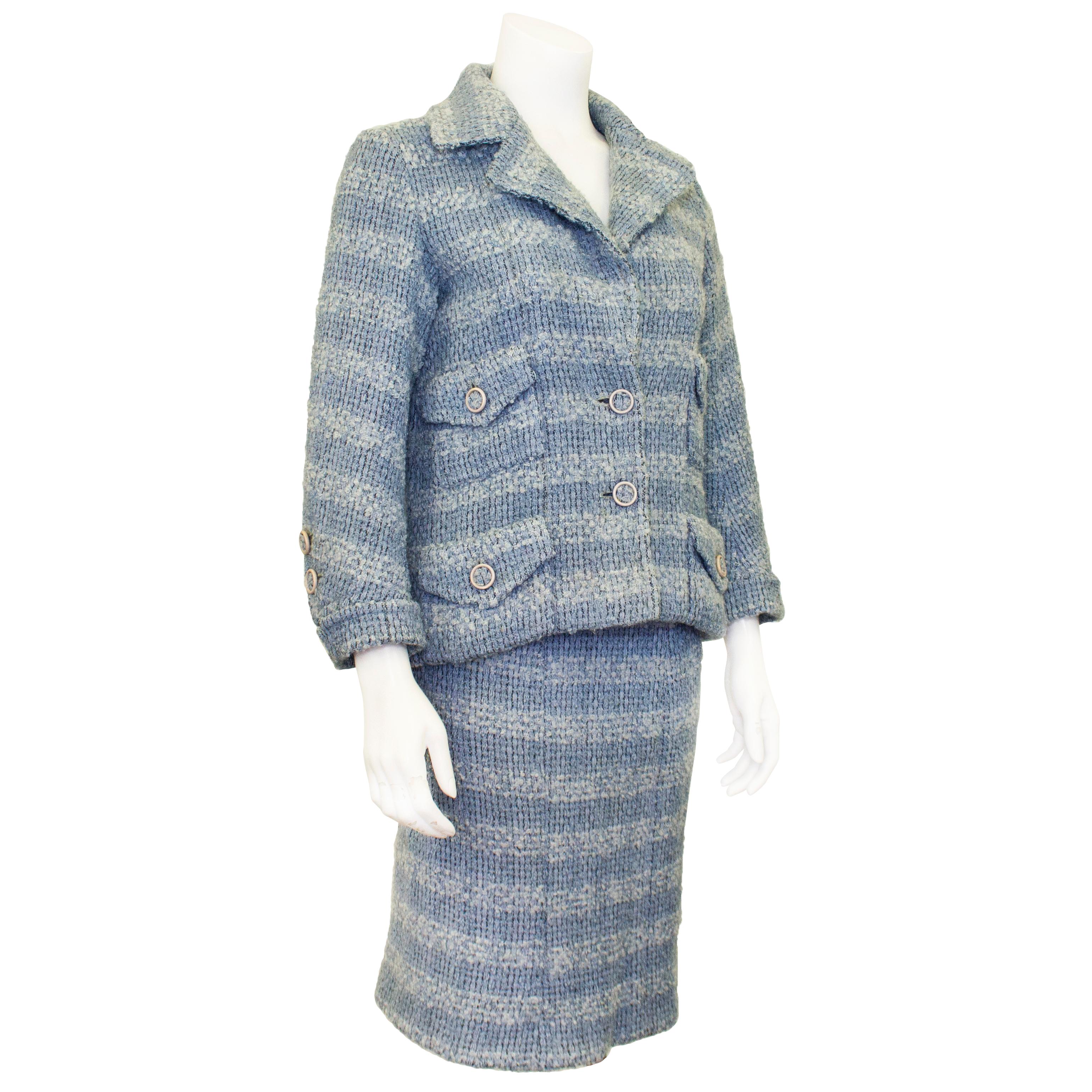 Beautiful Chanel Haute Couture suit dating from the 1950s. Alternating two tone pale blue wool tweed with matching blue tweed buttons with white trim. The jacket features a notched collar with four patch flap pockets and folded cuffs. The skirt is