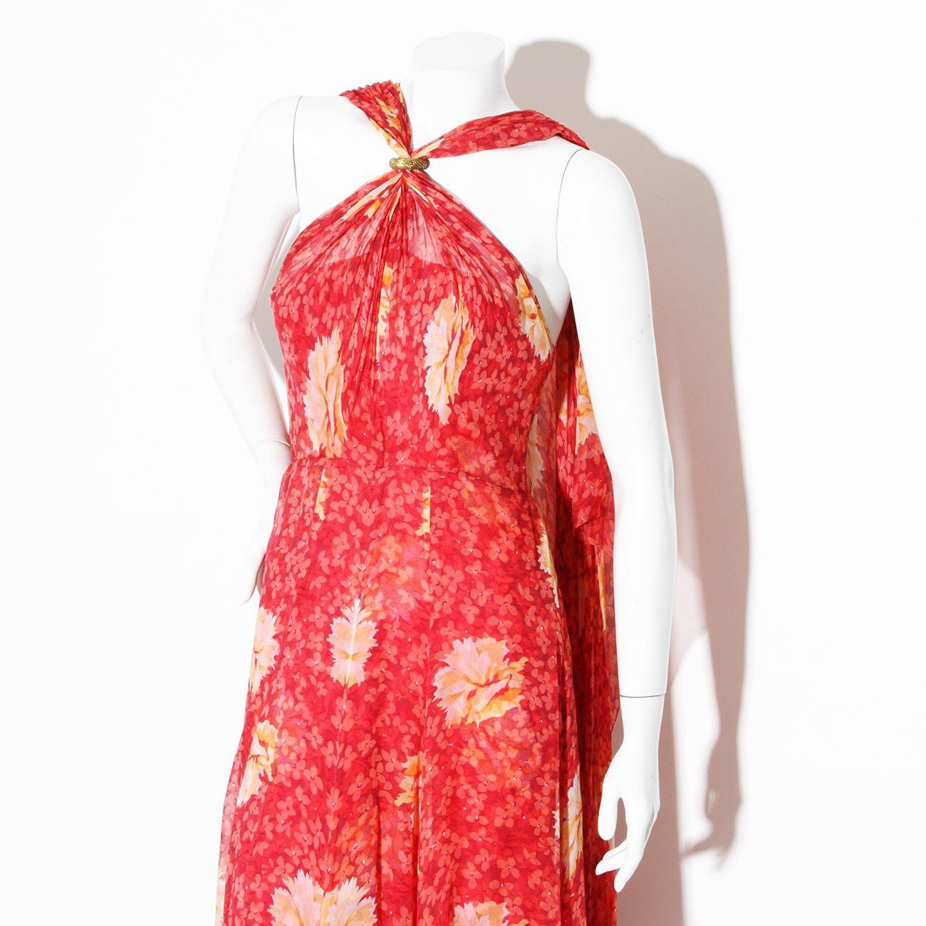 Product Details:
Vintage Haute Couture chiffon gown by Chanel
Lifetime Chanel Piece 
Late 60's Early 70's 
Halter top with gold clasp closure 
Clasp that holds halter is signed by Robert Goossens  
Bias cut chiffon fabric
Floral Print 
Zipper