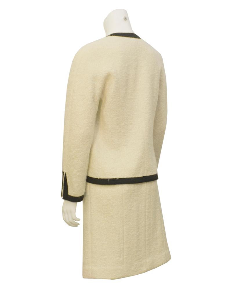Le tailleur Chanel Couture le plus classique qui soit. Lignes épurées, boucle blanche et passepoils noirs sur la veste et la jupe. Portée par Ines de la Fressange lors du défilé Chanel Haute Couture Automne/Hiver 1986-1987. Label Couture, pas de