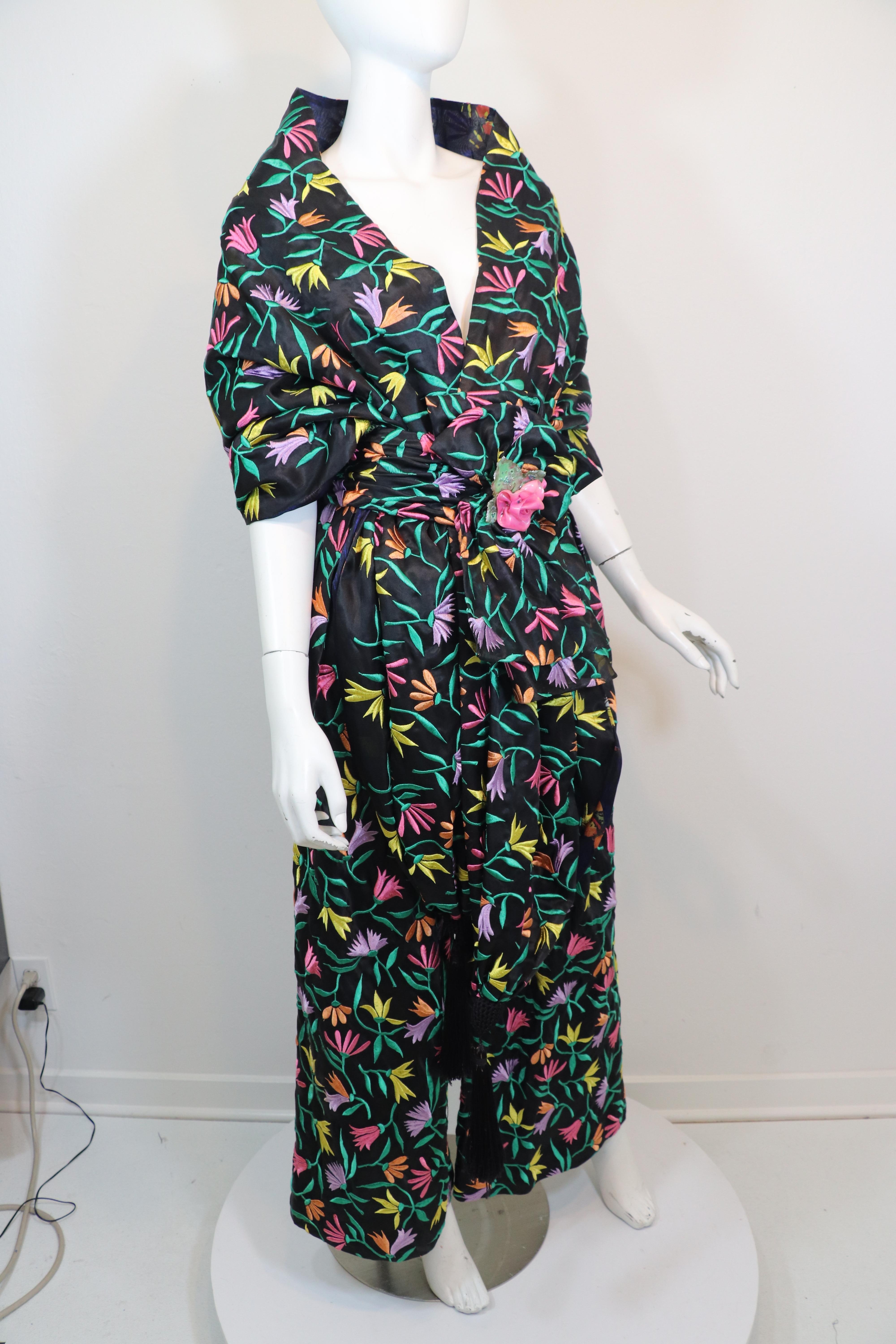 Chanel Haute Couture Lesage embroidered pants, shawl and belt ensemble. Black silk satin embroidered allover with pink, topaz, yellow, and lavender flowers with emerald green stems. Lined in black butterfly print silk organza. Black 9