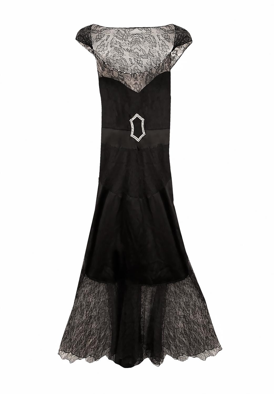 Il s'agit d'une très rare robe de couture Chanel des années 1940. 
Robe à la silhouette droite composée d'une jupe et d'un chemisier, délicat dos plongeant orné d'un nœud.
Matière : soie, dentelle 
Période : Années 1940, trouvaille de collection
La