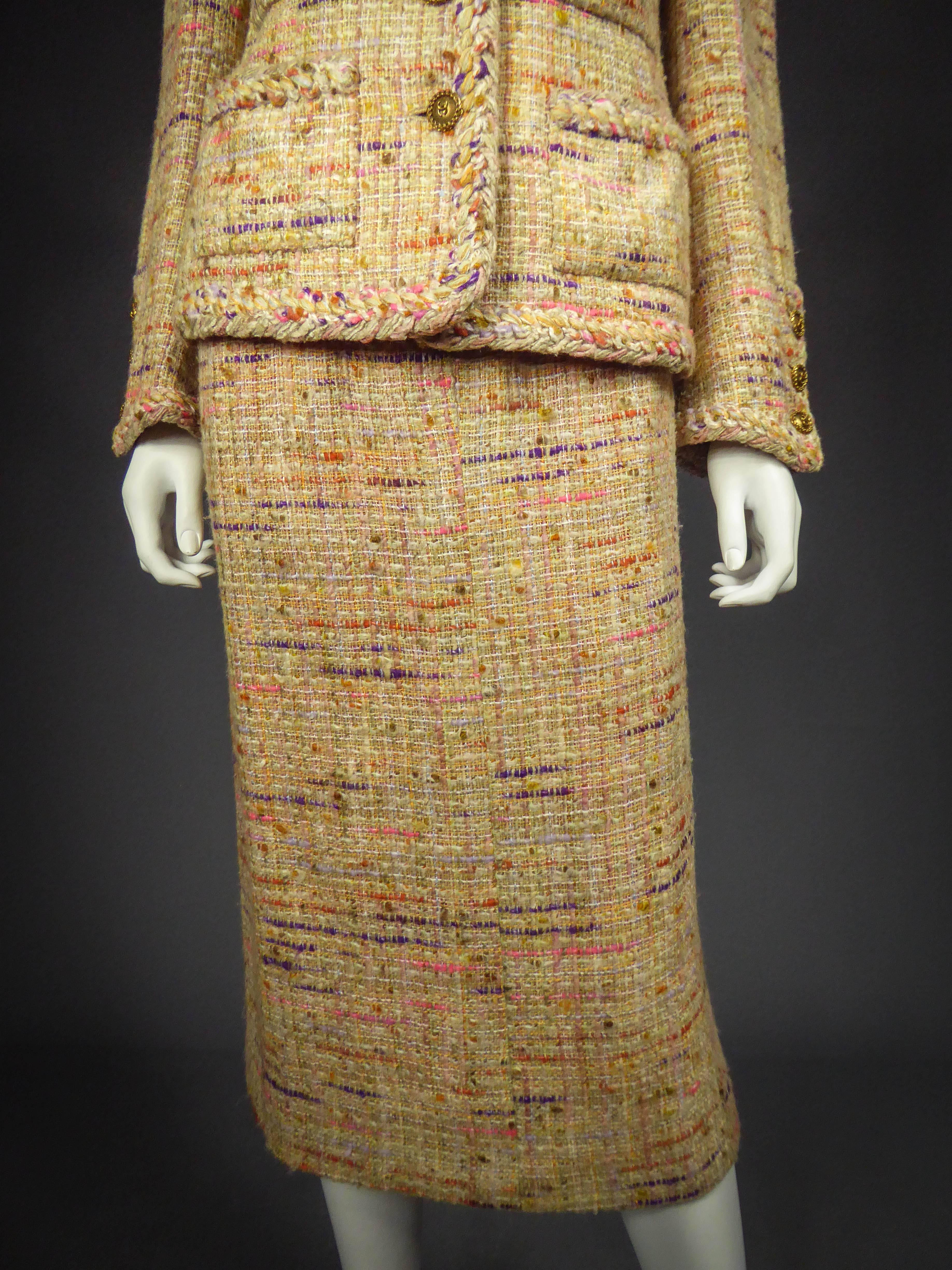 Circa 1979

France

Set skirt and jacket suit Chanel in flecked polychrome wool knit in shades of brown, purple, cream, yellow and blue sky. Jacket with small shoulder pads, pockets and cuffs entirely edged with a wool braid in the same fabric.