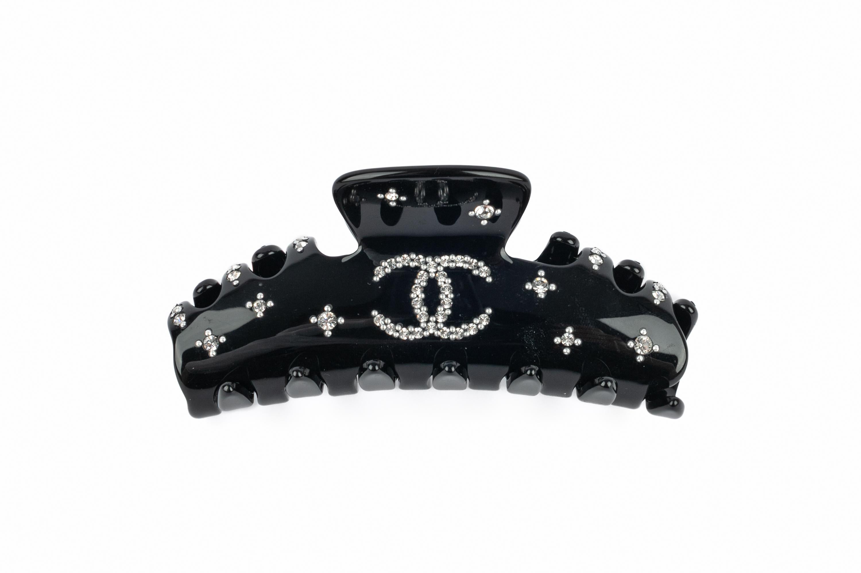 CHANEL - (Made in France) Black bakelite hairclip / hair accessory with rhinestones. 2009 Cruise Collection under the artistic direction of Karl Lagerfeld.

Condition:
Very good condition

Dimensions:
Length: 9 cm

SKU:BARB4