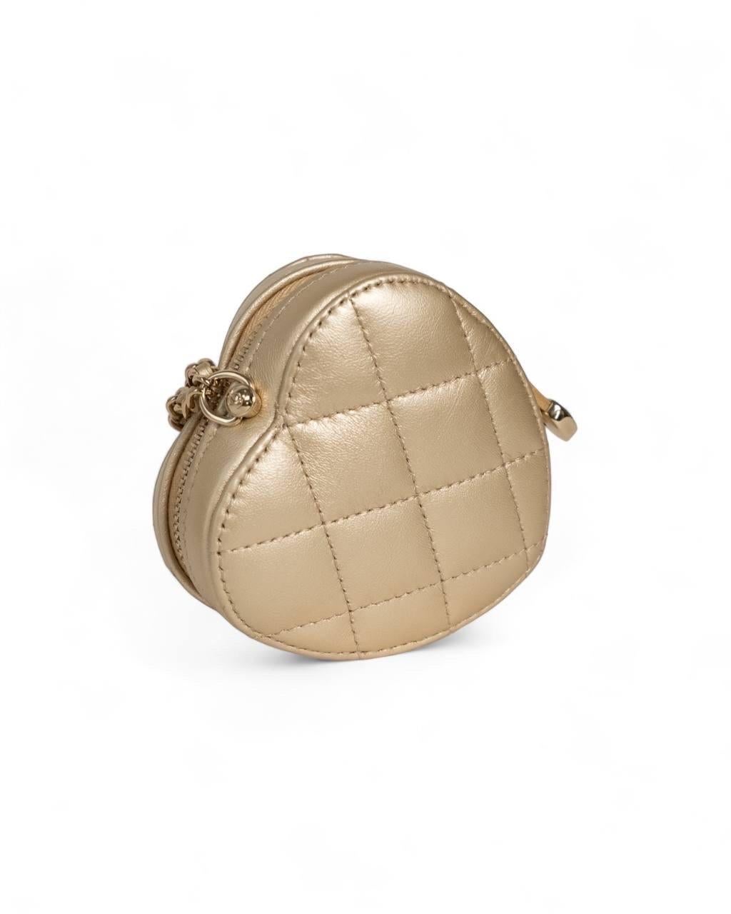 Borsa firmata Chanel, modello Heart, misura Micro, realizzata in pelle trapuntata color oro con hardware dorati. Dotata di una chiusura superiore semicircolare a zip, internamente rivestita in tela beige, capiente per l’essenziale. Munita di una