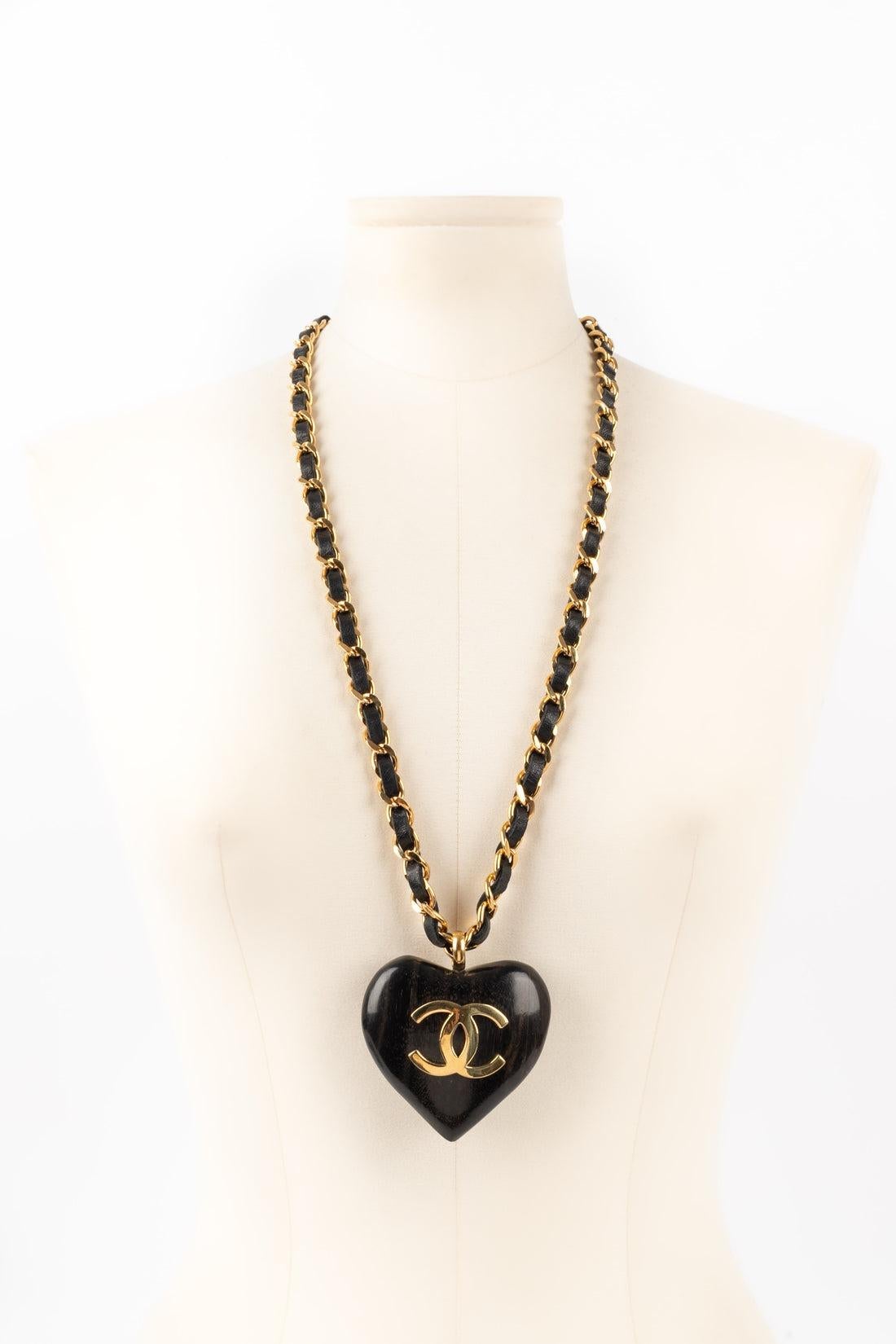 Chanel - (Made in France) Golden metal necklace with black leather and a wood heart topped with a cc logo. Spring-Summer 1992 Collection.

Additional information:
Condition: Very good condition
Dimensions: Length: 76 cm
Period: 20th Century

Seller