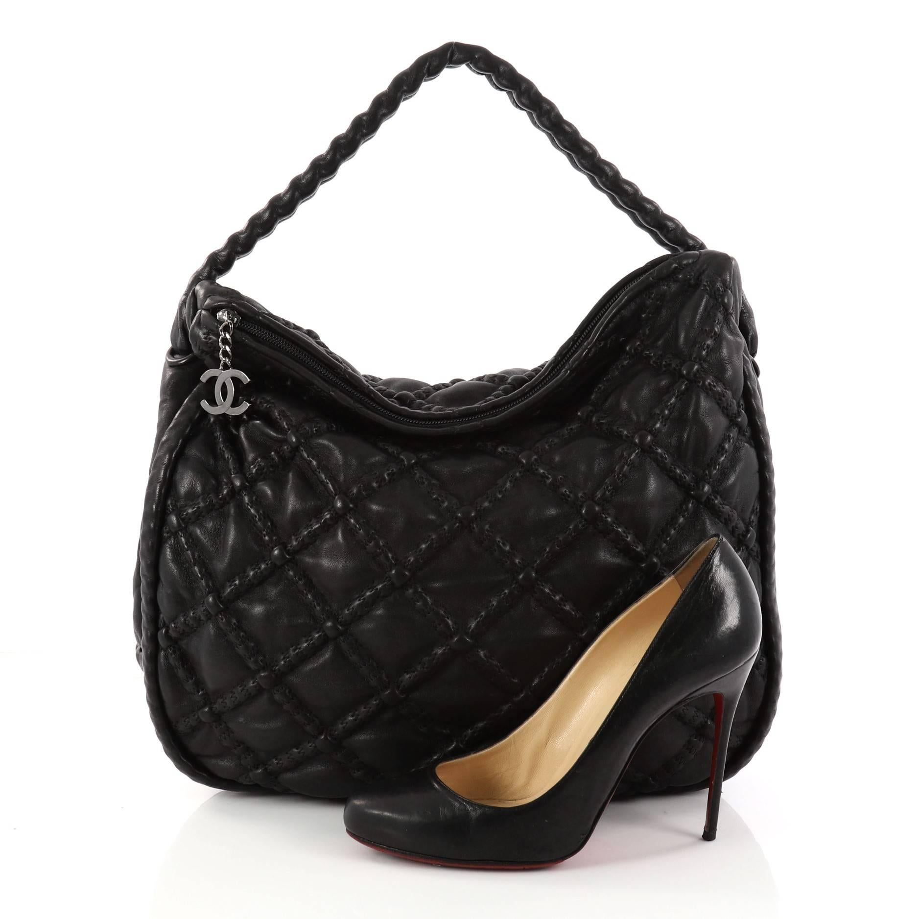 This authentic Chanel Hidden Chain Hobo Quilted Lambskin Large is an exquisite edgy hobo made for modern fashionistas. Crafted in black concealed quilted lambskin leather, this hobo features a hidden chain handle wrapped in leather, a CC zipper pull