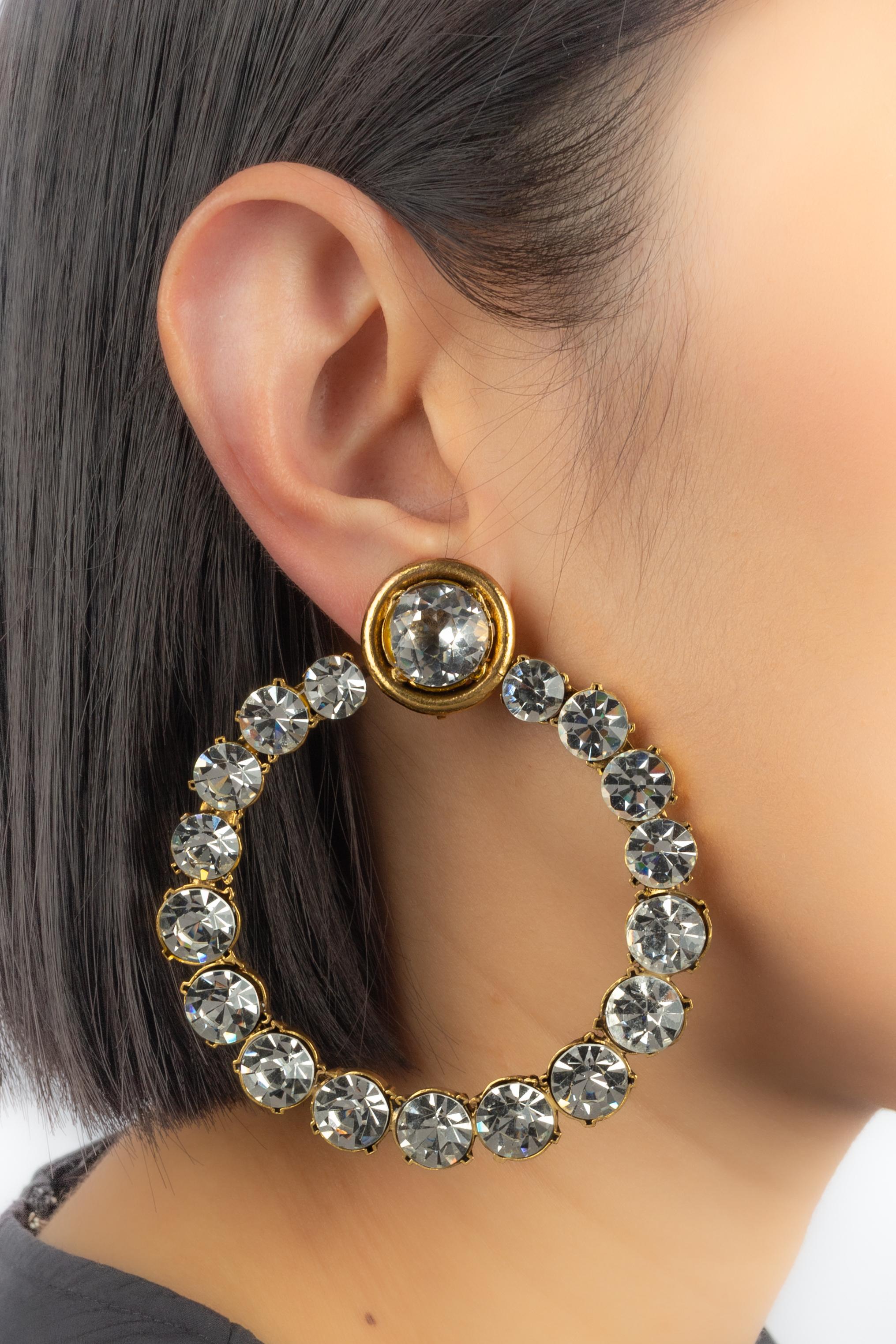 Chanel - (Made in France) Orecchini a cerchio in metallo dorato ornati di strass.

Condizioni:
Ottime condizioni

Dimensioni:
Altezza: 8 cm

SKU:BOB149