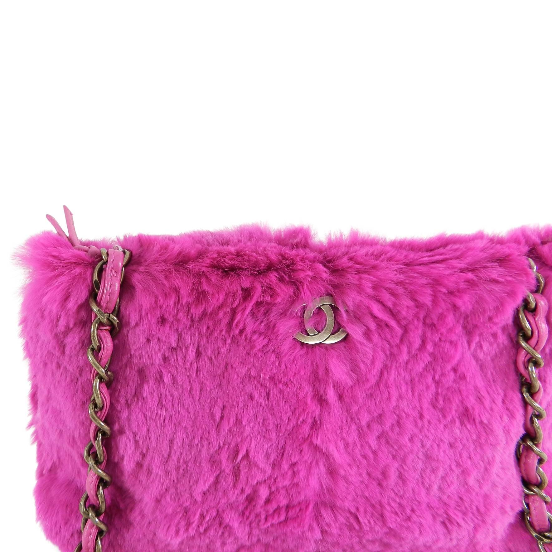 Chanel Hot Fuchsia Pink Rabbit Fur Bag.  Zippered top, CC logo at front, dark antiqued gold metal hardware.  Fabric lined interior is clean. Leather woven through chain strap shows some light wear. Includes authenticity card, duster, and care