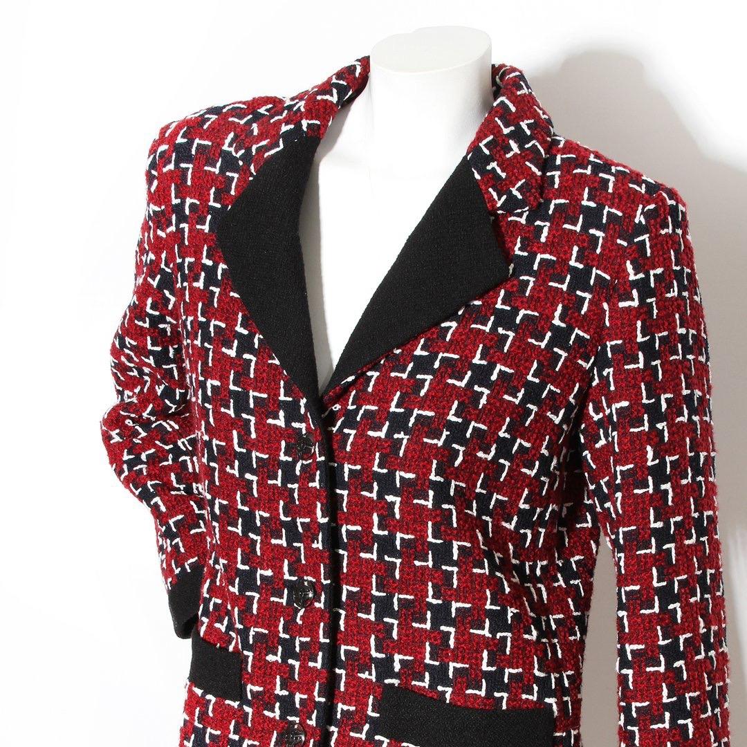 Houndstooth Jacket by Chanel
Burgundy with black and white details
Long sleeve
Collared
Button-down front closure
Black transparent buttons
Cuffed sleeves
Symmetrical open hip pockets
Black trim on collar, pockets, and bottom
Extra fabric and