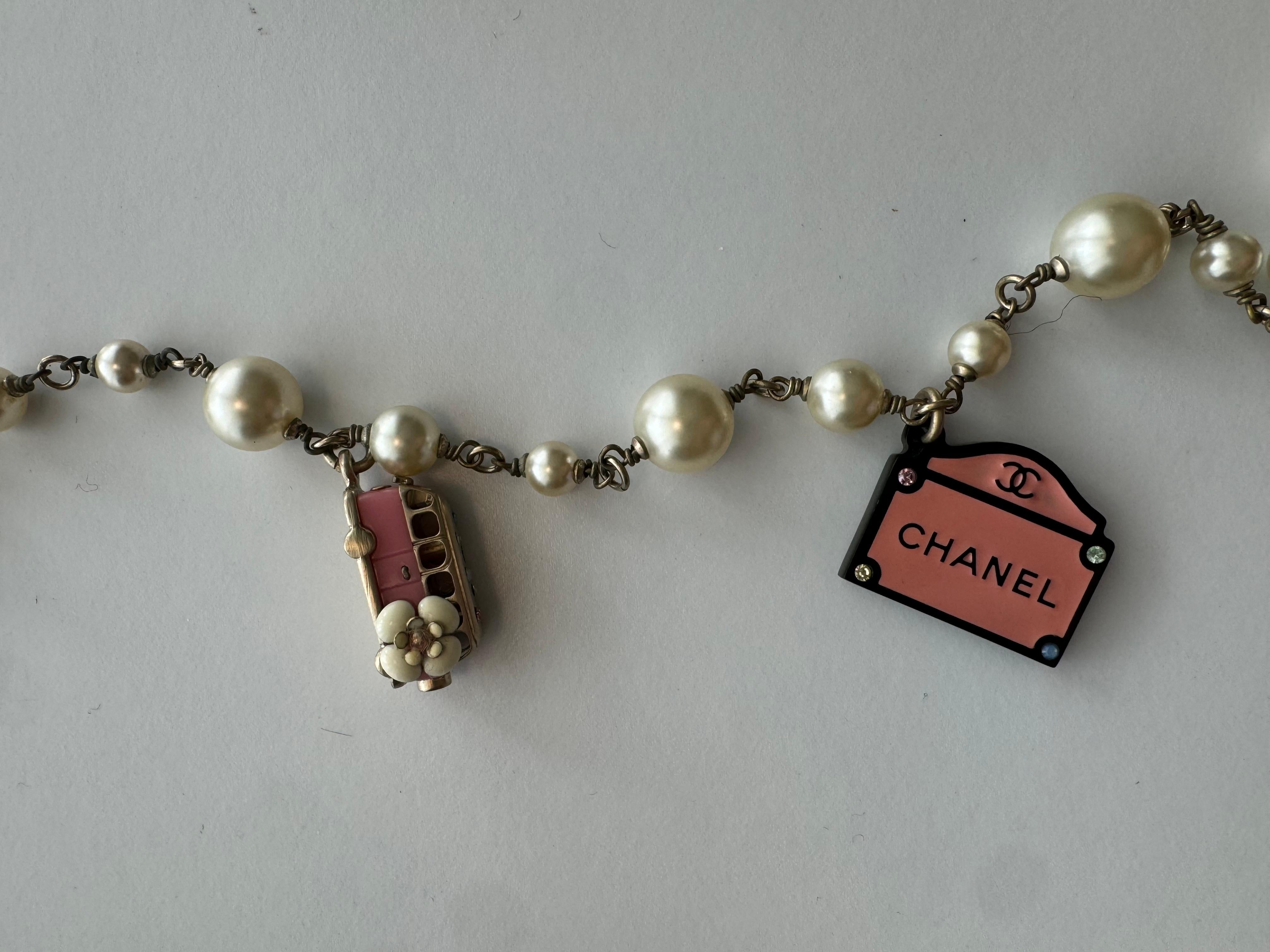 Chanel Gold Metal, Pink, Black, White Resin, Enamel, Strass, and Imitation Paris Souvenir Charm Necklace, 2006

Condition: Very good. light scratches on the pearls. none significant to note.
Length: approximately 84cm.

