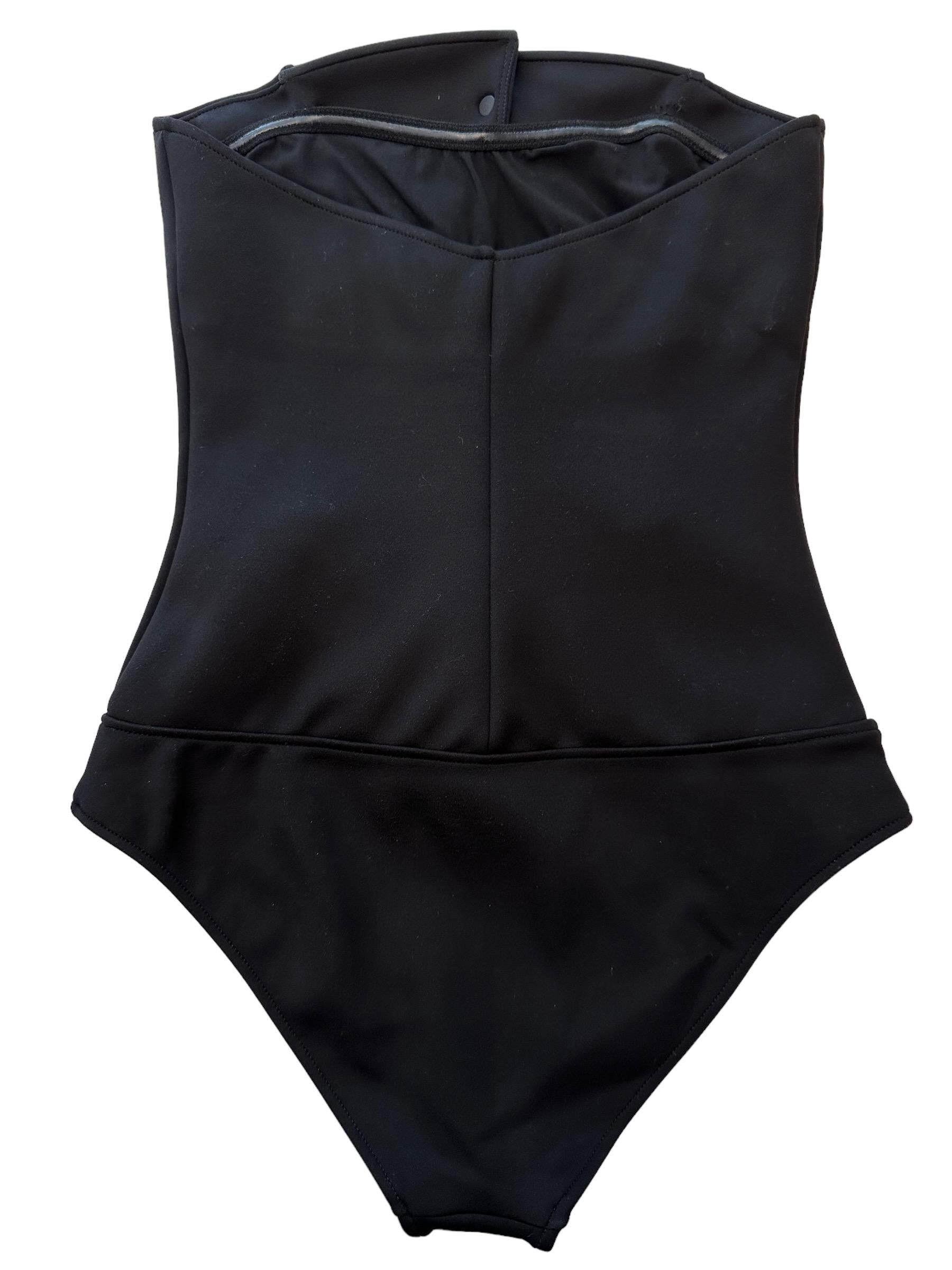 This pre-owned but new iconic one-piece swimsuit from the house of Chanel can also be worn as a body.
It features pearl buttons with a CC logo engraved and 2 straps to knot around the neck.

Fabric: 48% nylon - 34% polyester - 18% spandex
Lining: