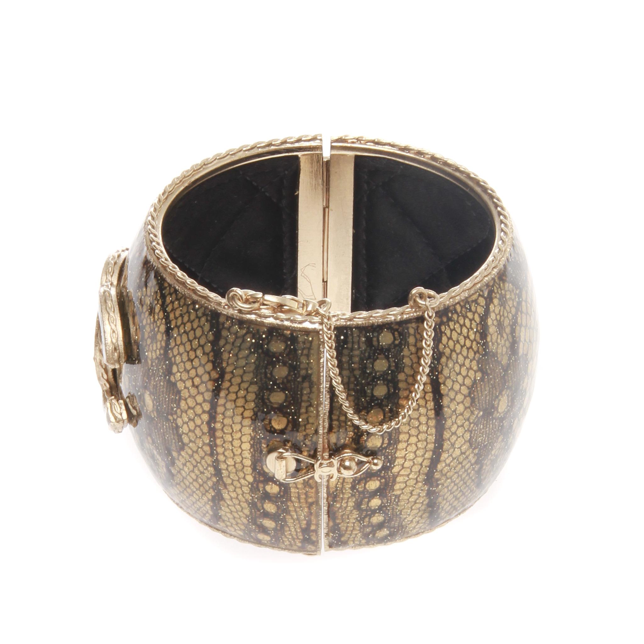 Ein unberührtes seltenes ikonisches CC Flora Spitze gemusterte Emaille Manschette Armband von CHANEL.

Dieses auffällige Chanel-Emaille-Armband ist mit dem ikonischen CC-Logo und einem Flora-Spitzenmuster verziert. Es hat ein gestepptes Innenfutter