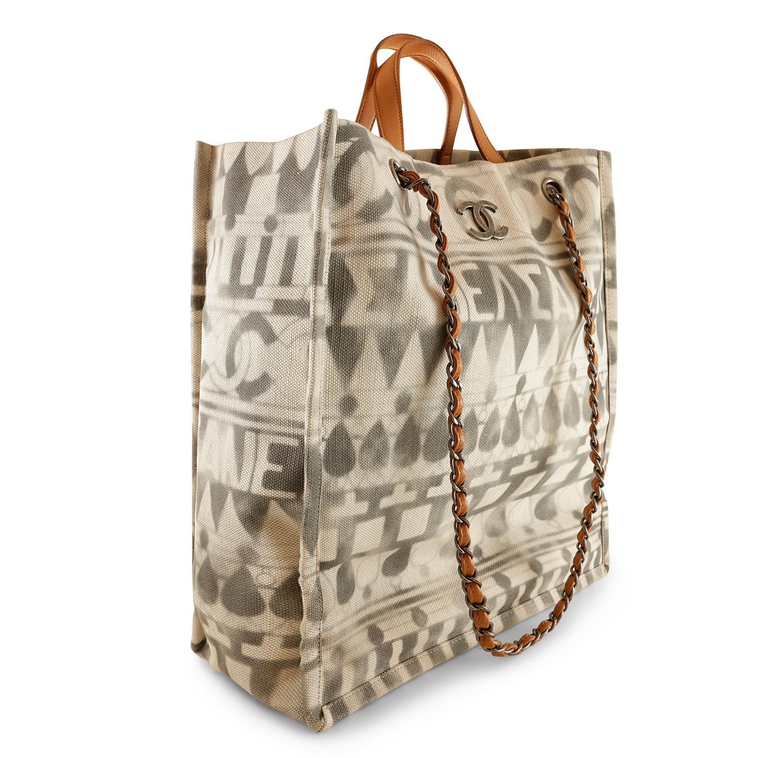 Chanel Iliad Printed Shopper Tote - pristine condition
Beautifully neutral with natural leather accents- perfect for everyday enjoyment.
Cream and grey printed canvas north south tote has Greek lettering and CC logos.  Natural leather short handles