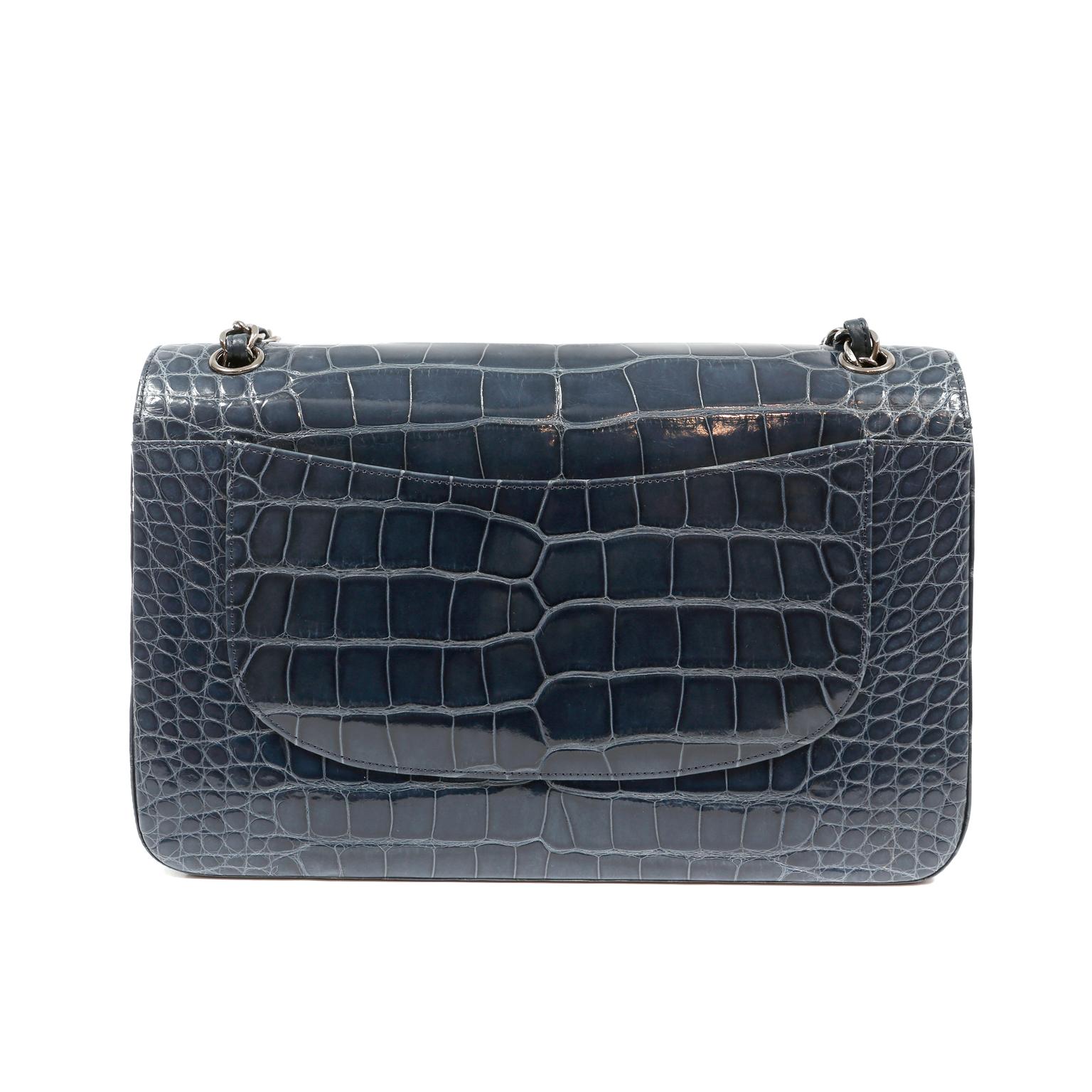 This authentic Chanel Indigo Blue Alligator Jumbo Classic is in pristine condition.  The highly coveted Jumbo Classic is elevated to new heights in this rare exotic version.
Deep indigo blue alligator skin is accented with dark silver interlocking
