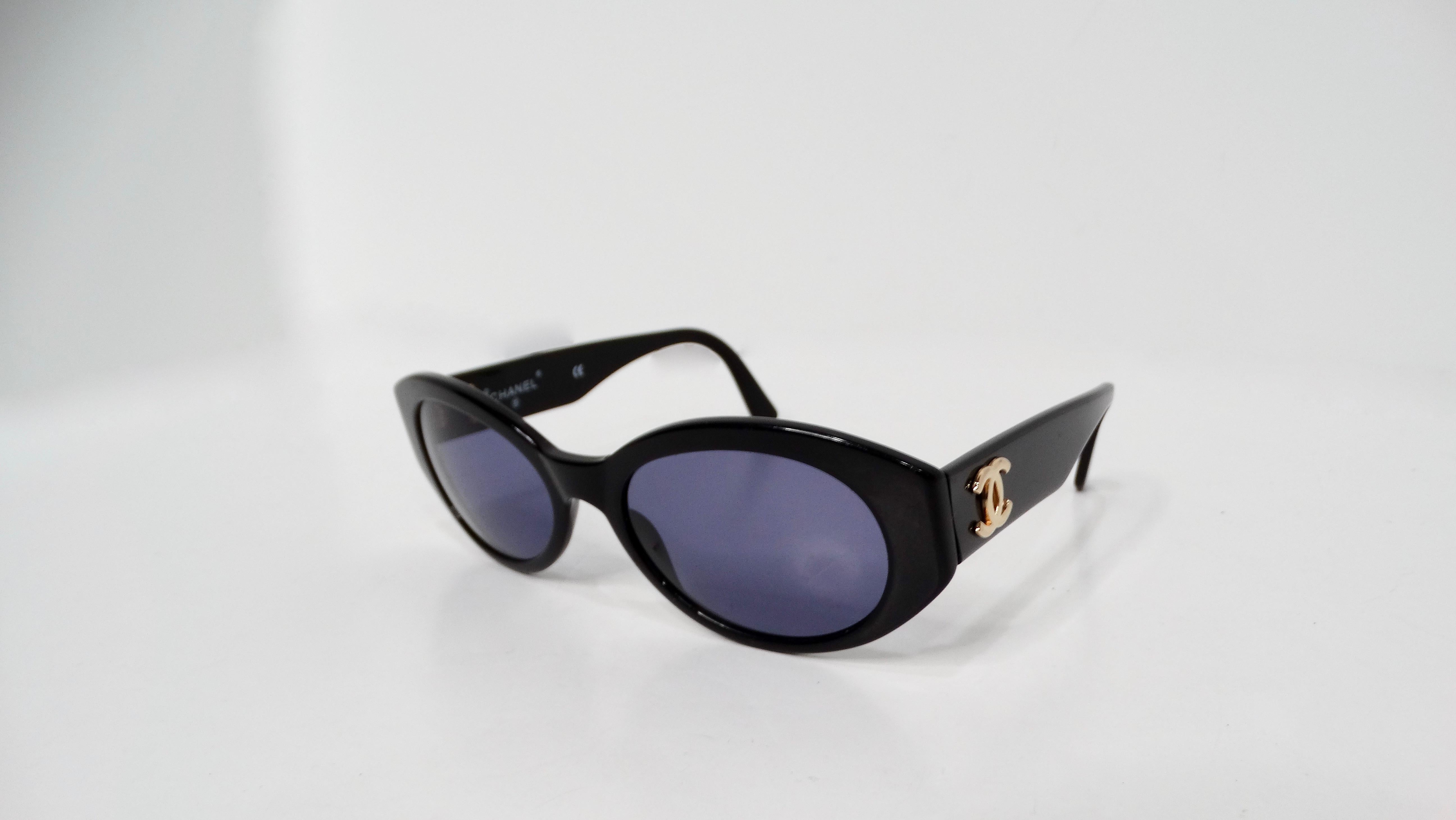 The 1990s Chanel Interlocking CC Black Oval Frame Sunglasses are a timeless accessory that exudes vintage sophistication and effortless glamour. Crafted with a sleek black oval frame, these sunglasses feature a subtle yet iconic gold-tone