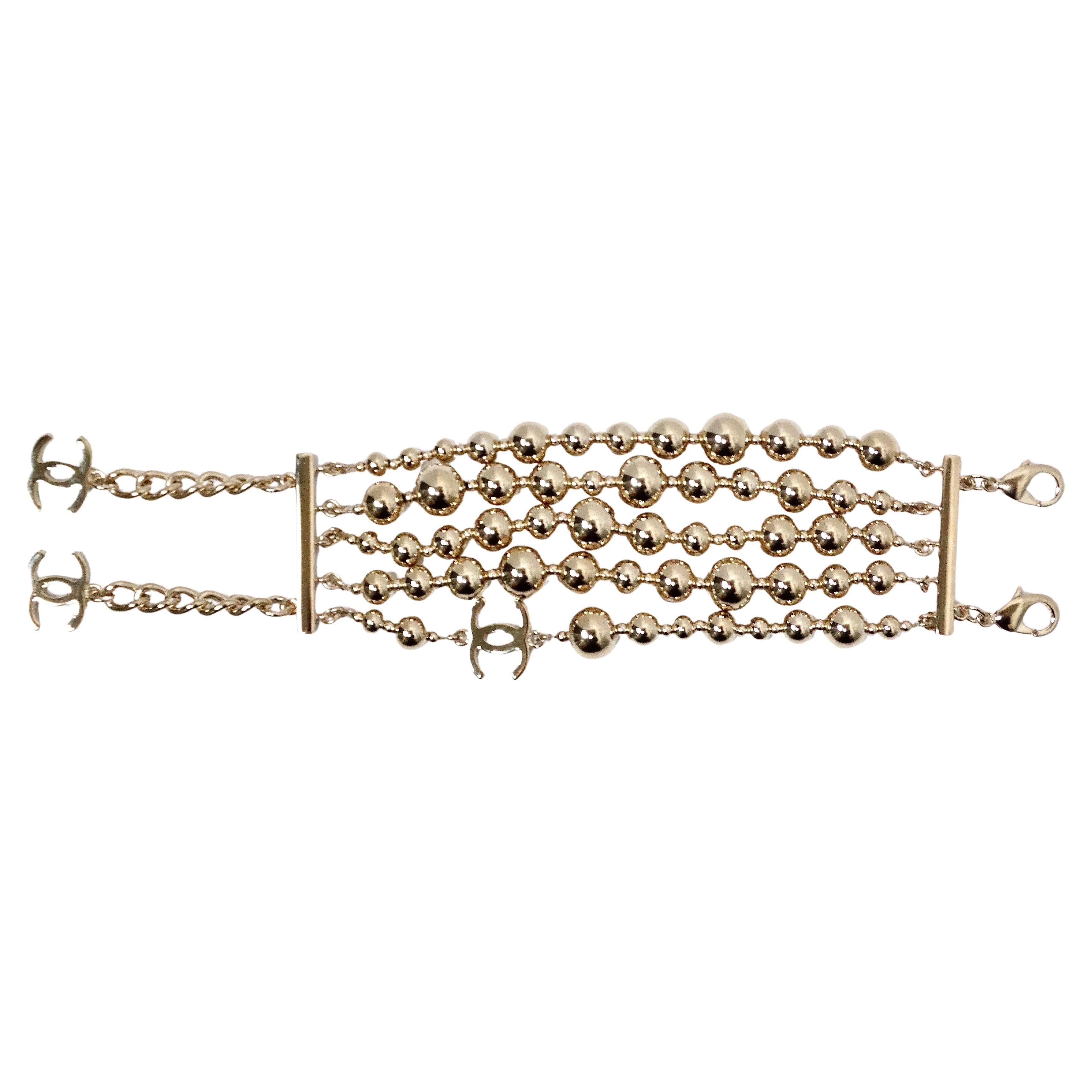 Le bracelet en perles multibrins à breloques CC imbriquées en or de Chanel est un accessoire luxueux et polyvalent qui incarne l'élégance intemporelle et la sophistication moderne. Réalisé avec un grand souci du détail, ce bracelet présente