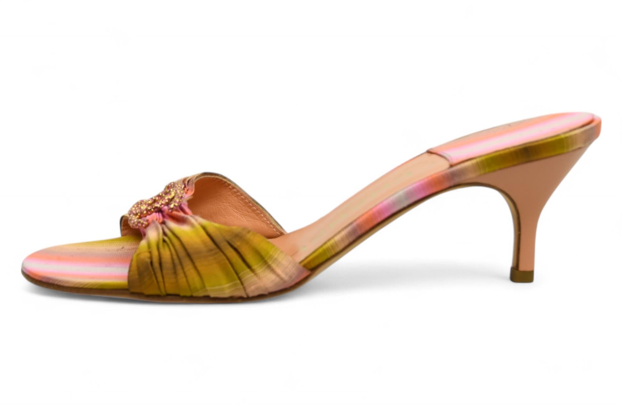 Entra nel puro glamour parigino con queste Chanel Crystal CC Tie-Dye Silk Mules: un'accattivante fusione di arte ed eleganza. Realizzate in seta lucida con un vibrante effetto tie-dye nelle tonalità del rosa, dell'arancio e dell'oro, queste mules