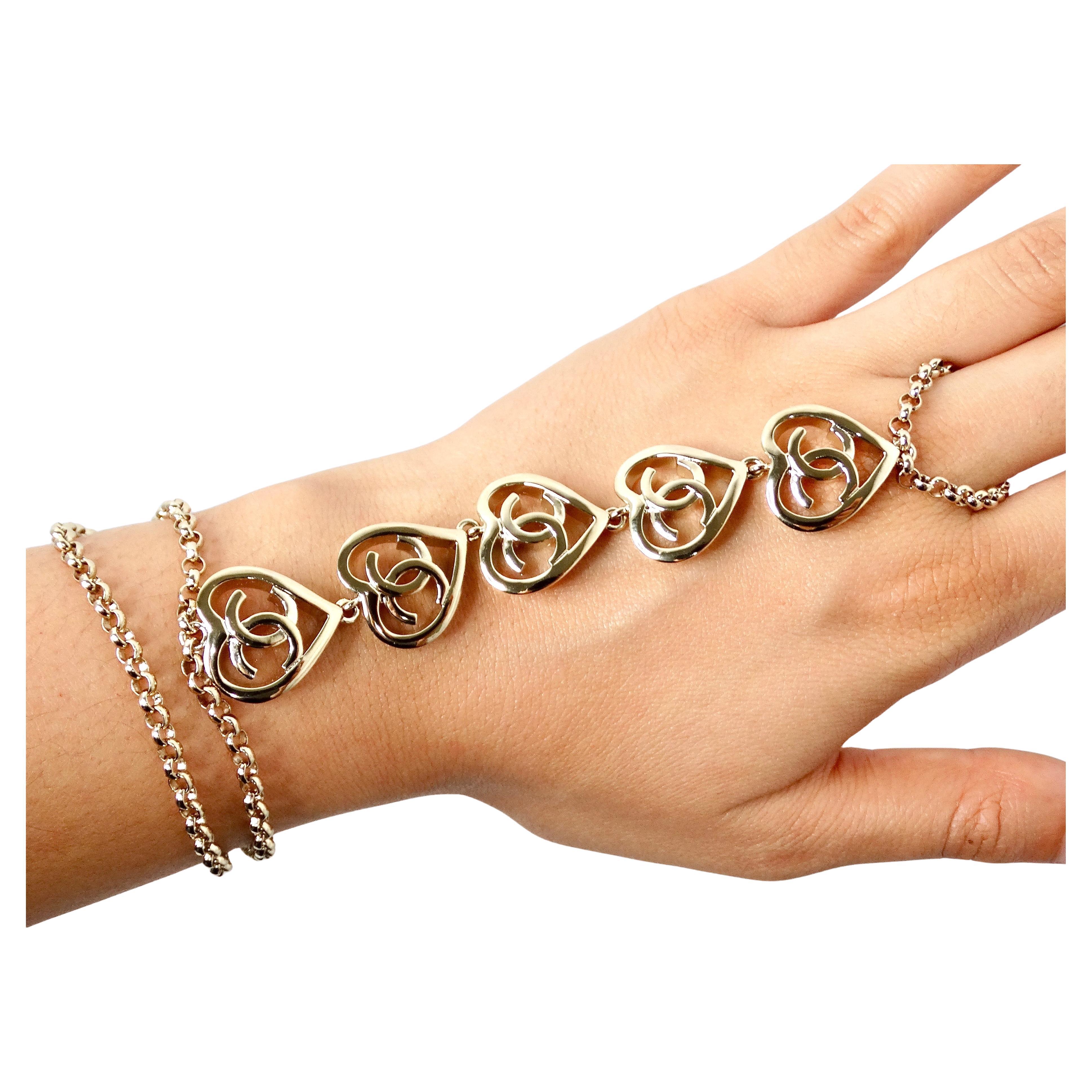 La pulsera o tobillera de eslabones corazón CC entrelazados Chanel 2022 es una impresionante pieza de joyería que combina a la perfección elegancia y versatilidad. Elaborada con una cadena dorada, esta pieza incluye delicados colgantes de corazón