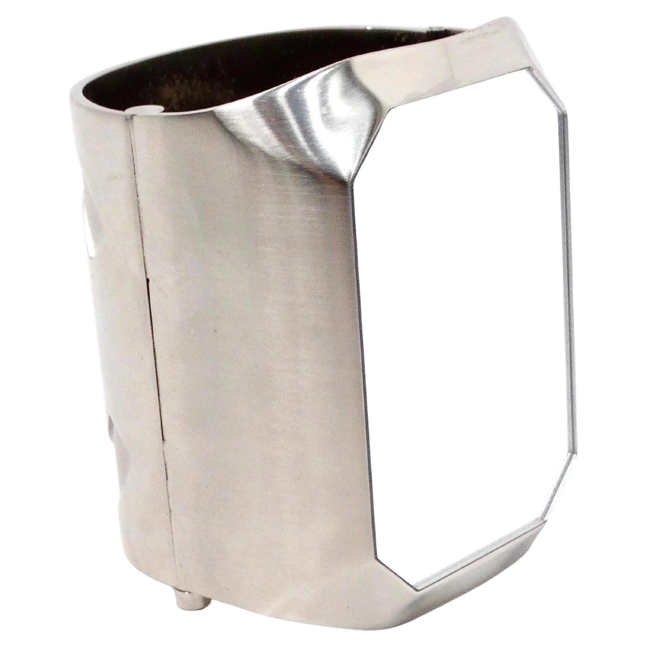 Das Chanel Interlocking CC Silberfarbenes Manschettenarmband mit Spiegel ist ein raffiniertes und vielseitiges Accessoire, das ikonische Markenzeichen und moderne Eleganz nahtlos miteinander verbindet. Das aus hochwertigem, silberfarbenem Metall
