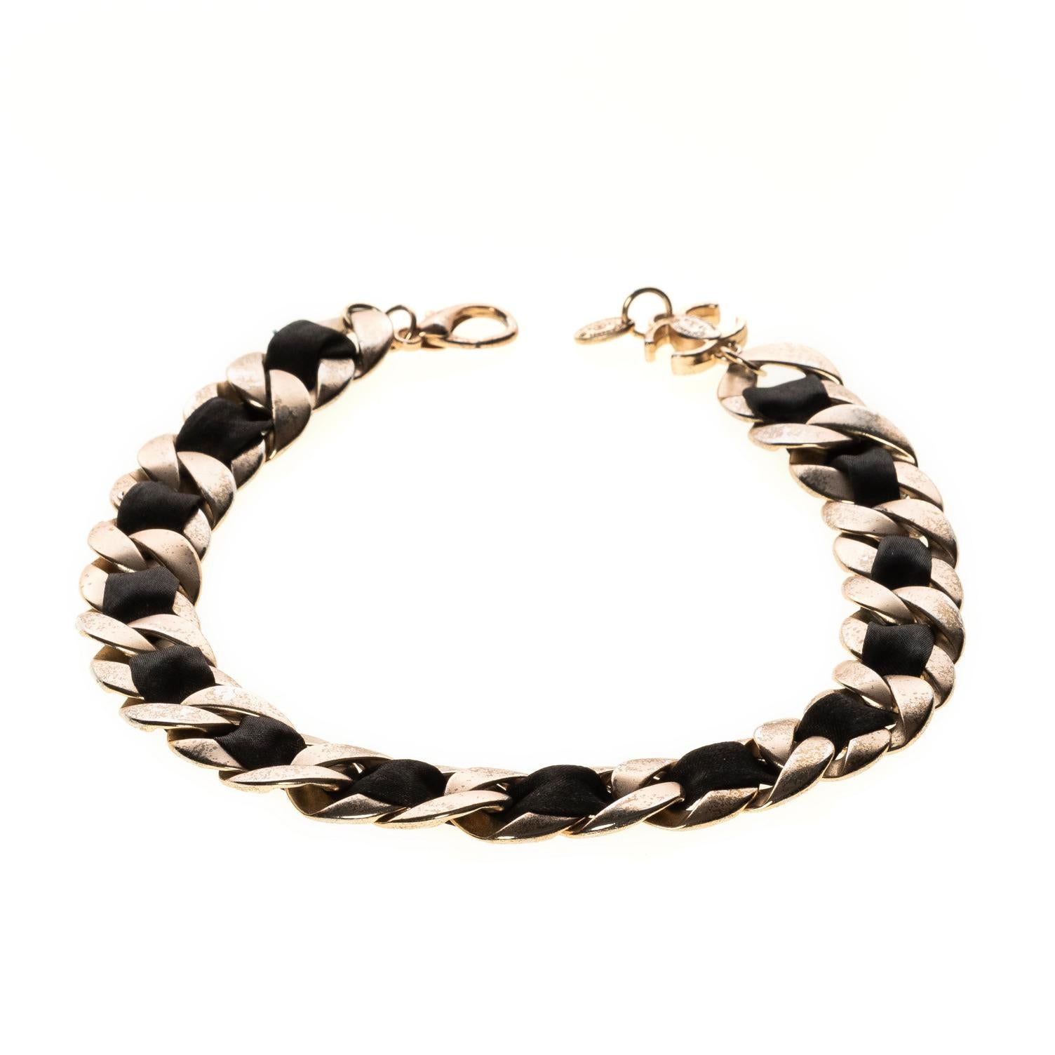 Chanel choker with a matte silver metal chain interlaced with black satin ribbon, clip at the end with CC logo. From 2009 Cruise collection. 

COLOR: Silver and black
MATERIAL: Metal & satin
ITEM CODE: 13 A
MEASURES: W 2cm, L 40.5 cm
EST. RETAIL: