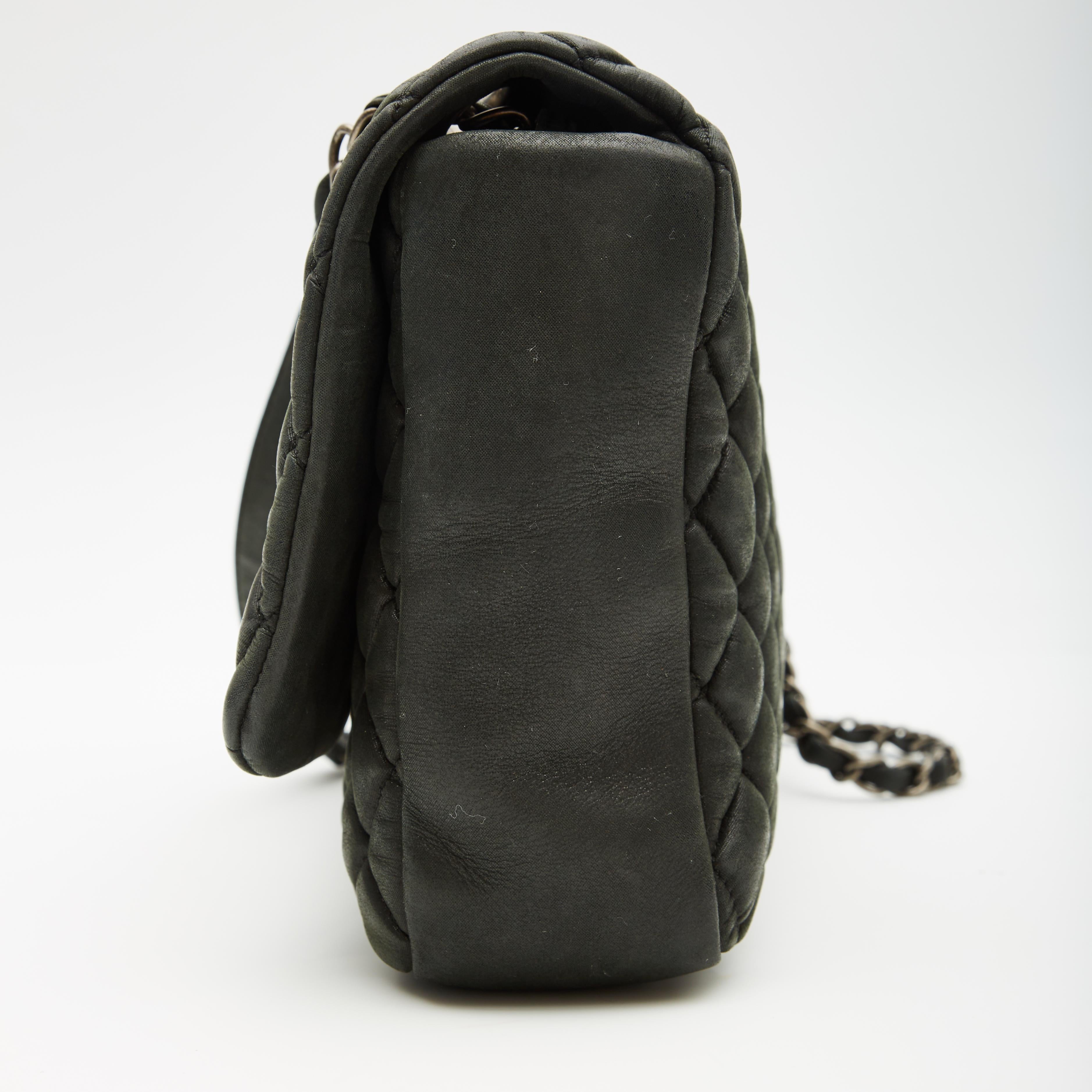 Diese Überschlagtasche ist aus schimmerndem, irisierendem, gefülltem Kalbsleder gefertigt. Die Tasche hat silberne Schulterriemen aus Kettengliedern, die mit passendem Leder verflochten sind, und ein Schulterpad aus Leder. Die Vorderklappe wird mit