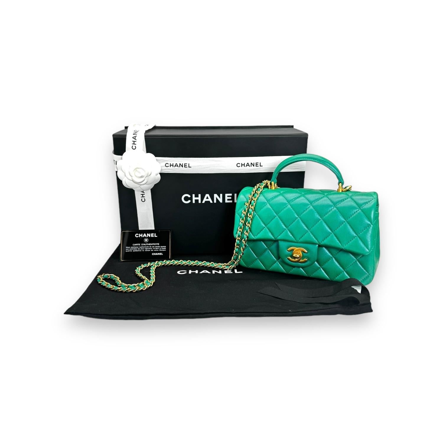 This stunning Chanel mini flap top handle bag is a timeless and chic accessory that is perfect for any occasion. The bag is crafted from luxurious lambskin leather in a beautiful iridescent green color that shimmers in the light. The bag features