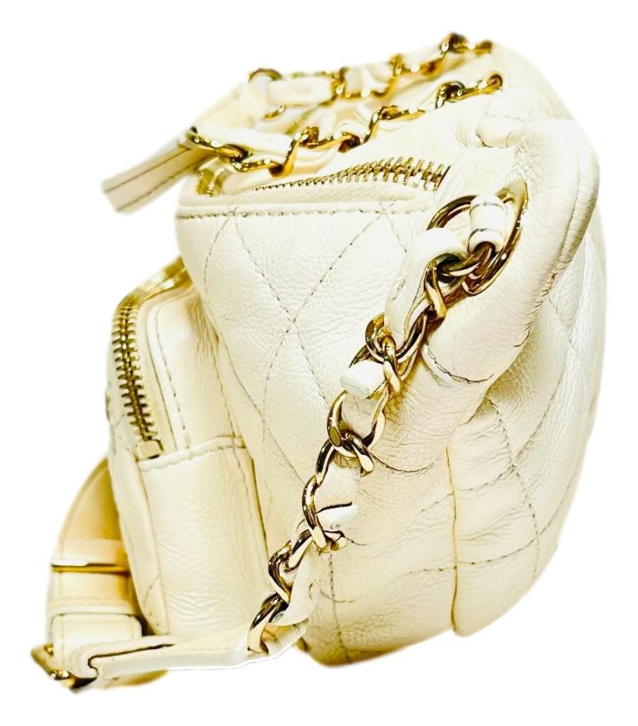 Chanel Iridescent Leather All About Waist Belt Bag

Off-white bag crafted in iridescent calfskin diamond quilted leather and designed with woven-in leather chain link and adjustable leather waist strap.

Featuring exterior zip pockets, gold hardware