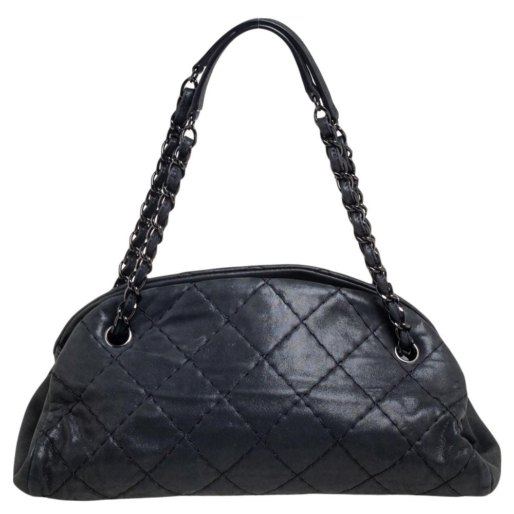 Spacious and captivating, this Just Mademoiselle Bowler bag is from Chanel. It has been crafted from leather and features the iconic quilted pattern. It is equipped with two chain handles and well-sized canvas compartments to keep your essentials