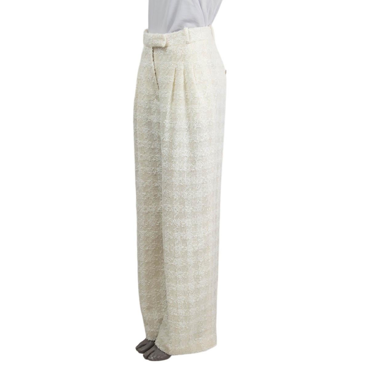 100% authentic Chanel lurex houndstooth tweed pants in with and ivory polyamide (73%) and wool (27%). Features a wide-leg with two concealed pockets on the side and two pockets in the back with buttons. Closes with a concealed zipper and two hooks