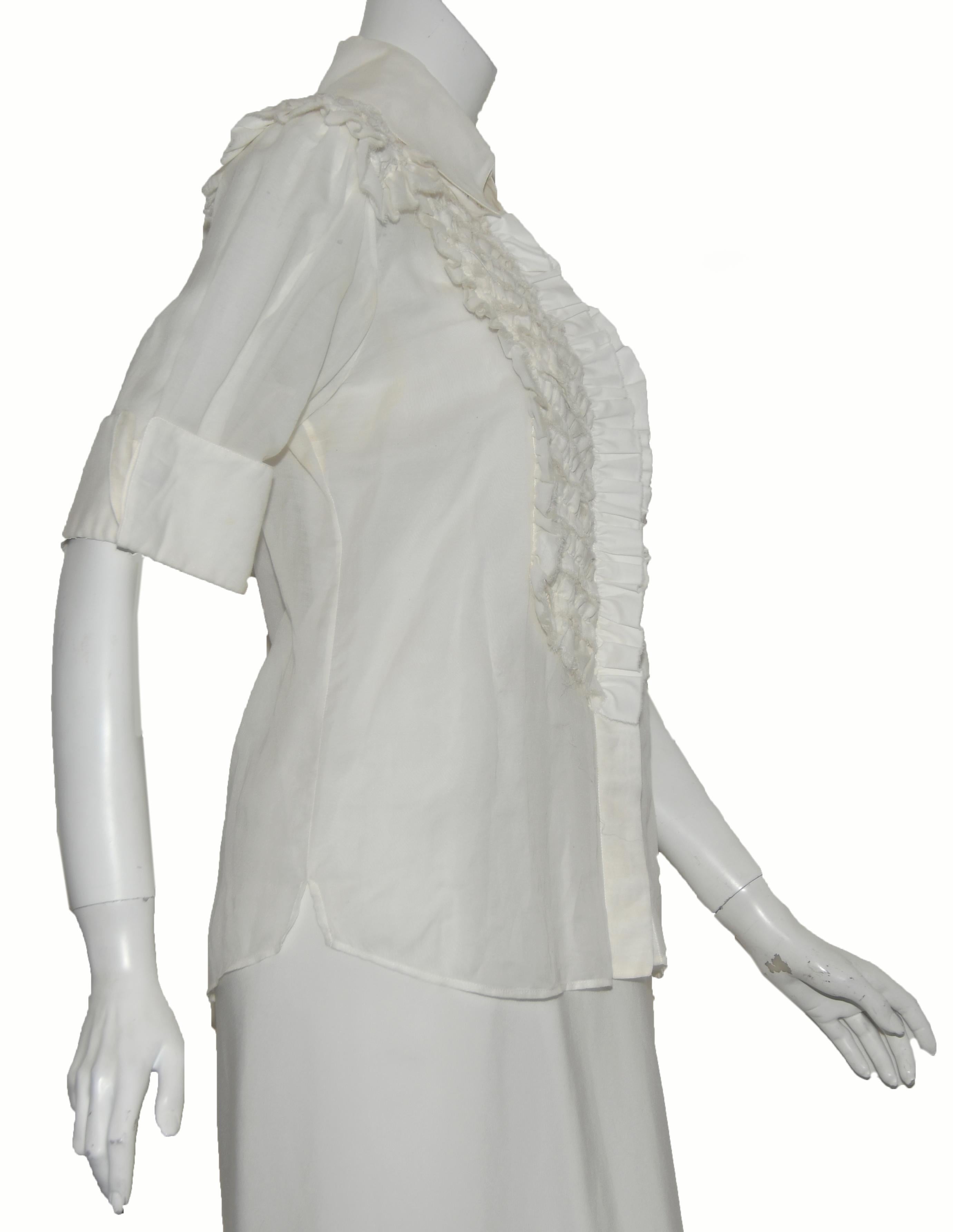 Chanel ivory 3/4 sleeve blouse contains tuxedo style small ruffles at front on each side of opening. The ruffles continue across the shoulders and down the back with a single ruffle placket.  This top is not lined.  On the sleeves a single CC button