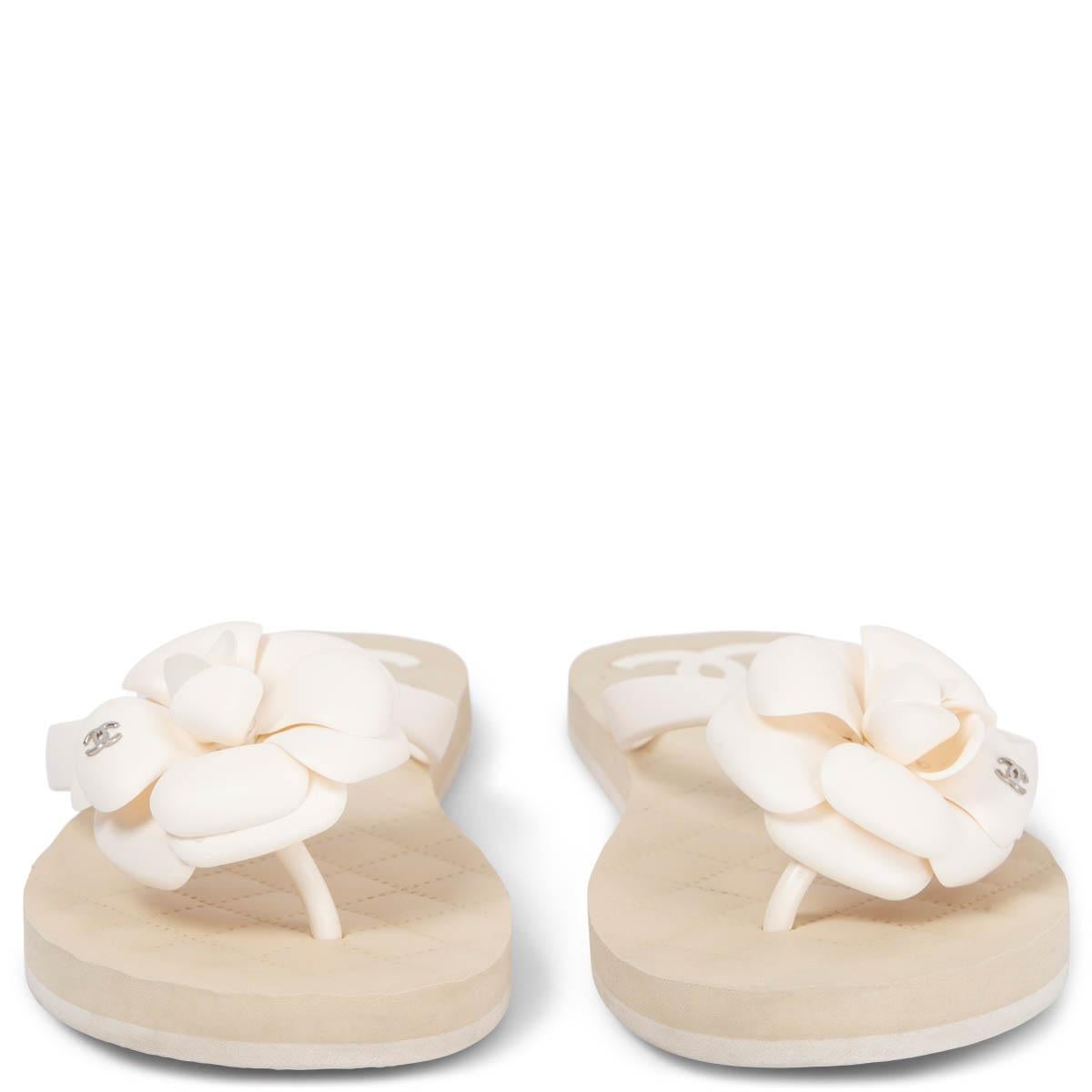 100% authentic Chanel thongs sandals in ivory & sand rubber embellished with a rubber Camellia and CC silver-tone metal logo. Have been worn and show very soft marks on the Camellia, one small leaf fell off and there are a few soft marks on the