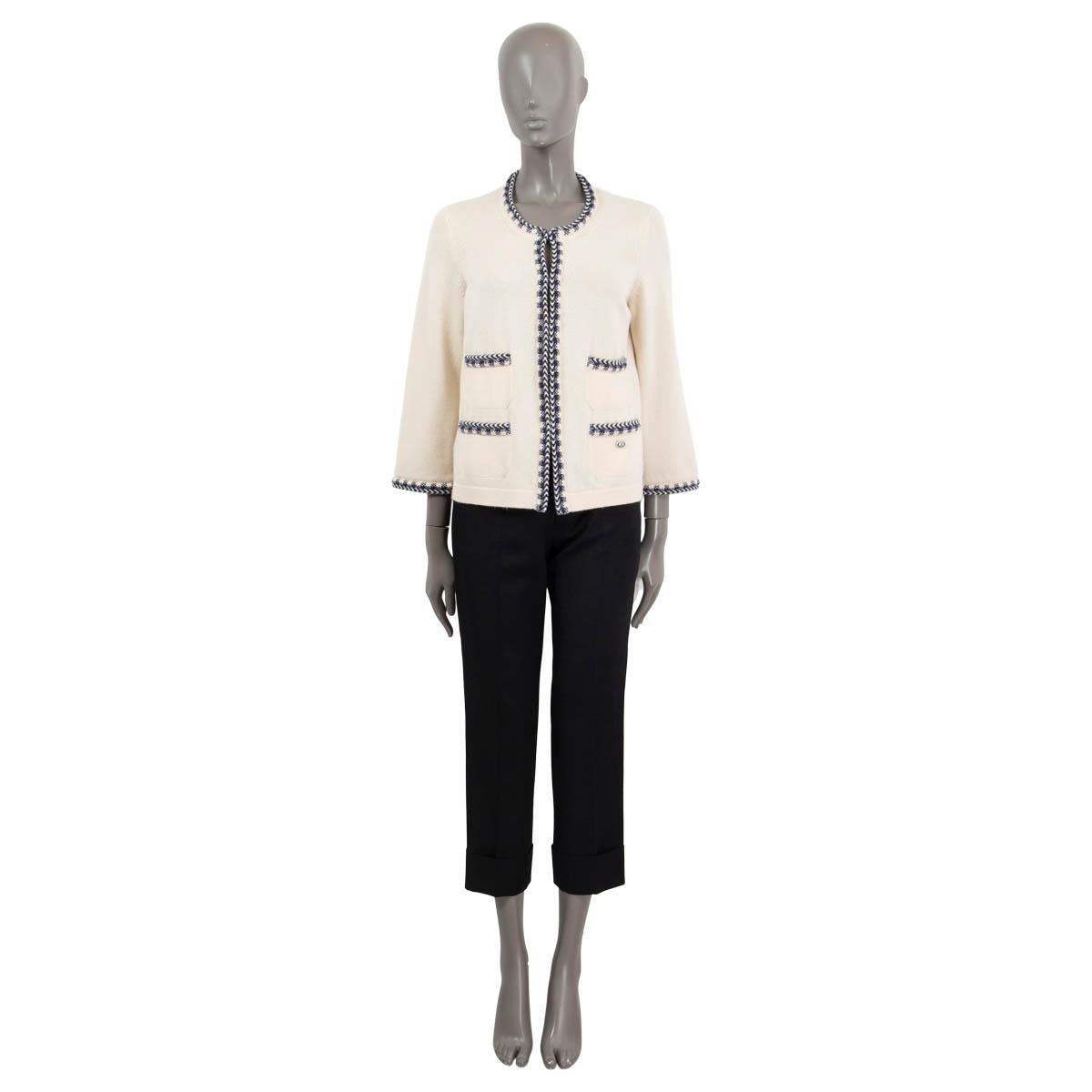 100% authentic Chanel four pocket cardigan in ivory cashmere (100%) with contrasting blue trim. Features a crewneck and 3/4 sleeves. Closes with hooks on the front. Has been worn and is in excellent condition.

2016 Paris-Seoul