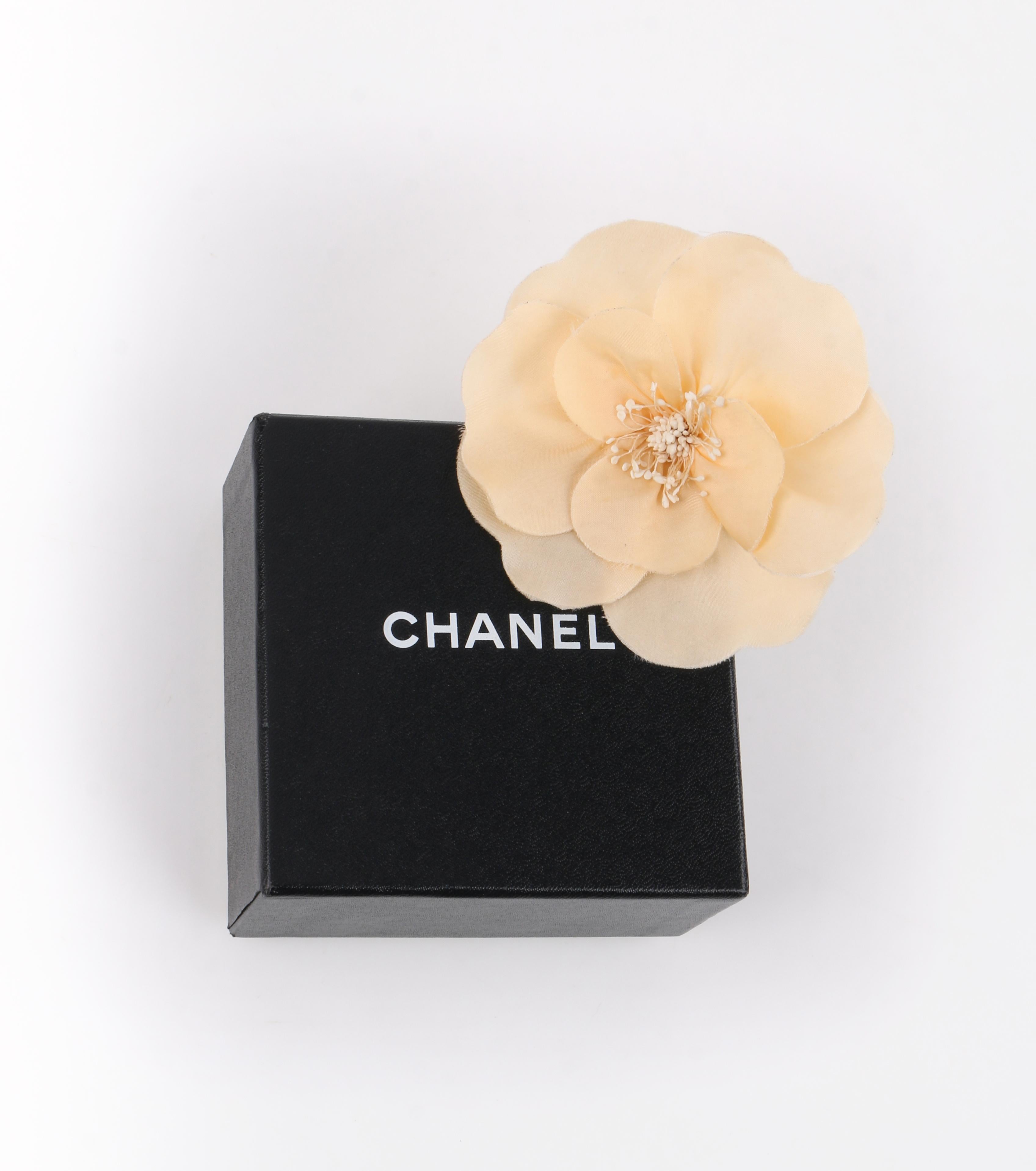 CHANEL Ivory Cream Beige Camellia Flower Brooch Pin + Box
 
Estimated Retail: $400

Brand / Manufacturer: Chanel
Style: Pin, brooch, corsage  
Color(s): Shades of ivory, brown and gold. 
Unmarked Material: Wool
Additional Details / Inclusions: Ivory