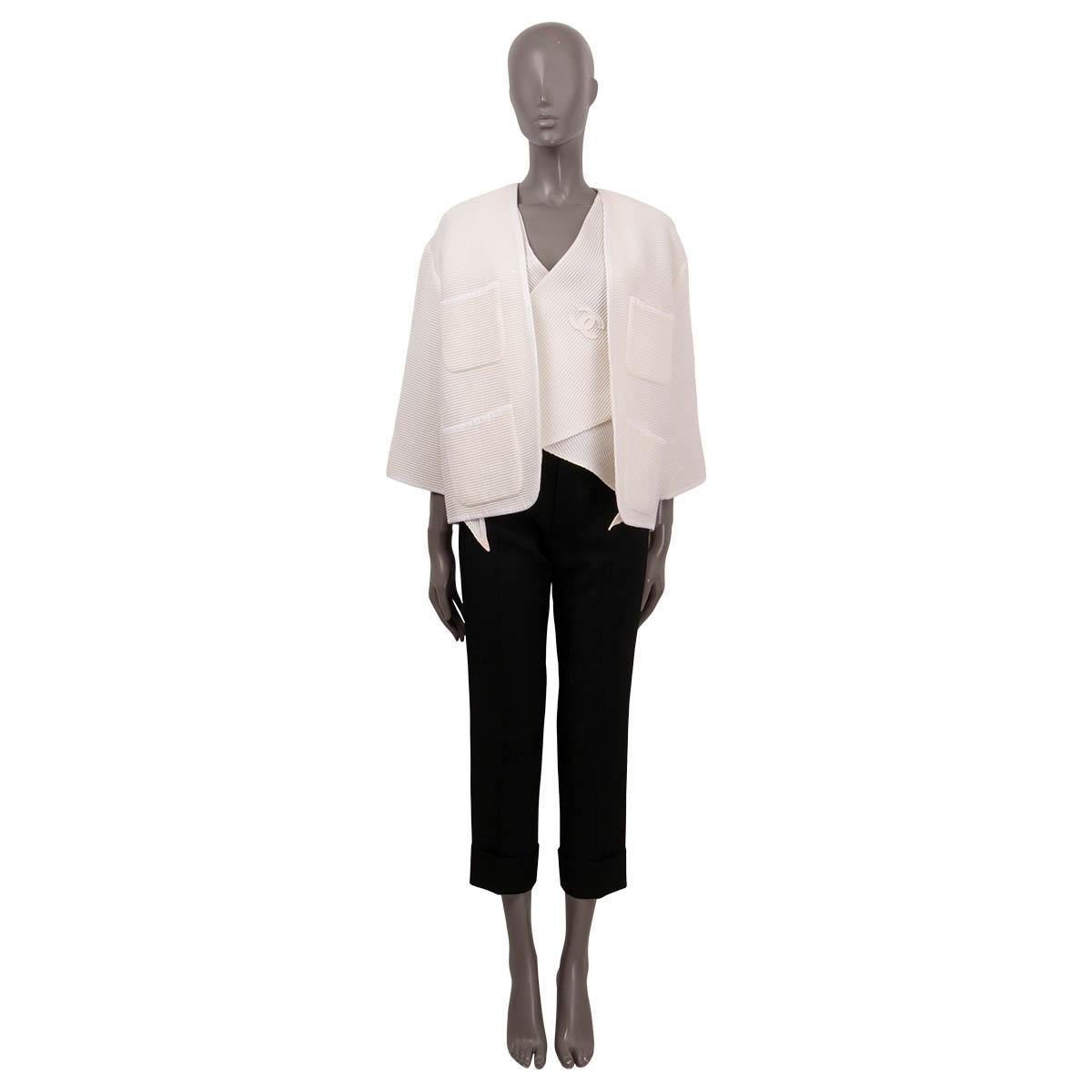 100% authentic Chanel layered knit jacket in ivory cotton (81%) and polyamide (19%). Double lined in ivory colored silk (100%). Features 3/4 sleeves, four slit pockets in the front and a ivory colored vest underneath, which is attached inside on the